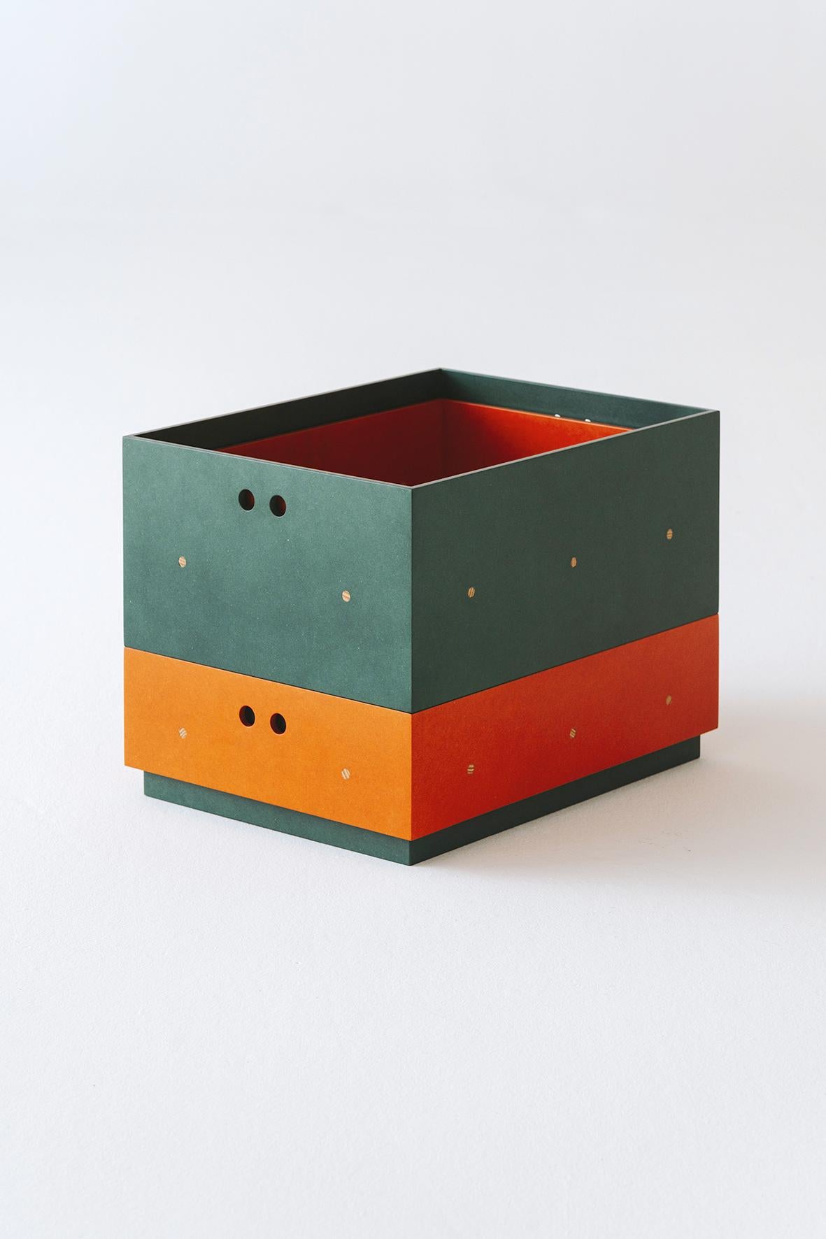Olmo are a pair of stackable boxes with 2 different heights. They are made with different layers of MDF and plywood, what creates a light and resistant structure that allow them to stack them.

The 2 different colors of the boxes help to