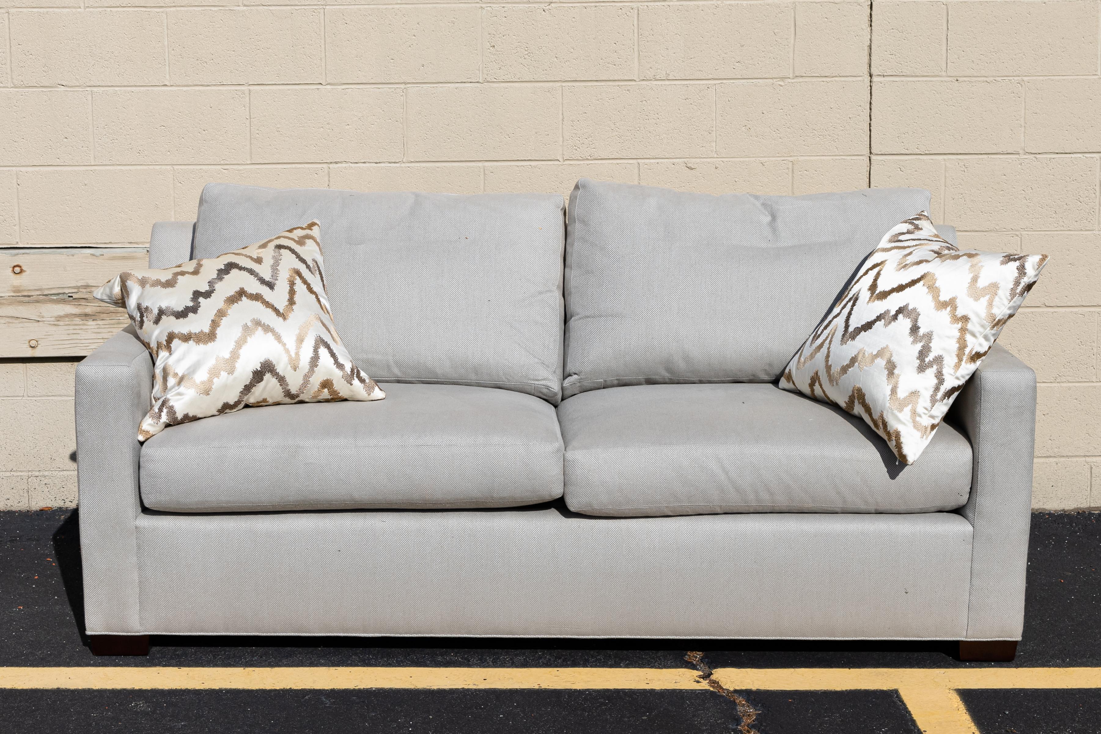 A modern contemporary Baker love seat. This sofa comes with matching cushions and pillows. They are removable from the piece. This piece is in very good condition with only slight wear around the legs common with used condition. This sofa measures