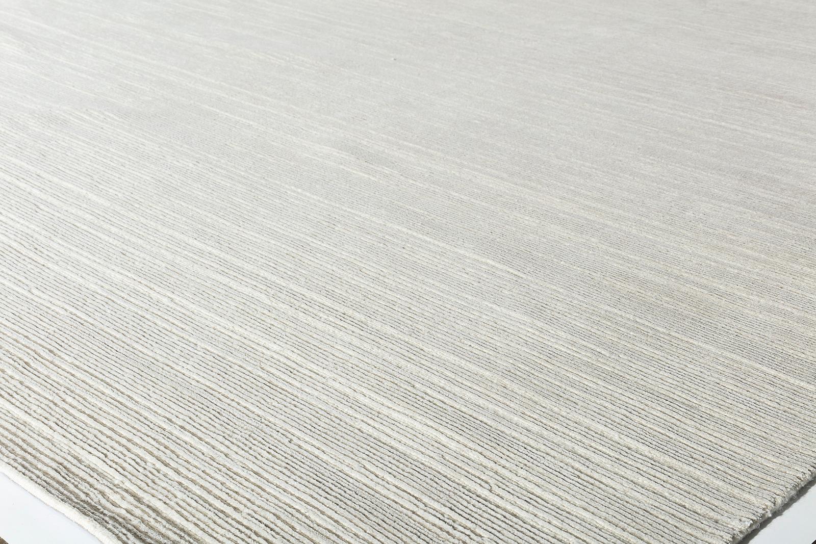 This luxurious Tibetan handknotted rug is comprised of wool and pure silk in beige and silver color. It has a loop and cut pile giving it nice, subtle texture and movement. 
Custom color and size available. Rug size is 9'0