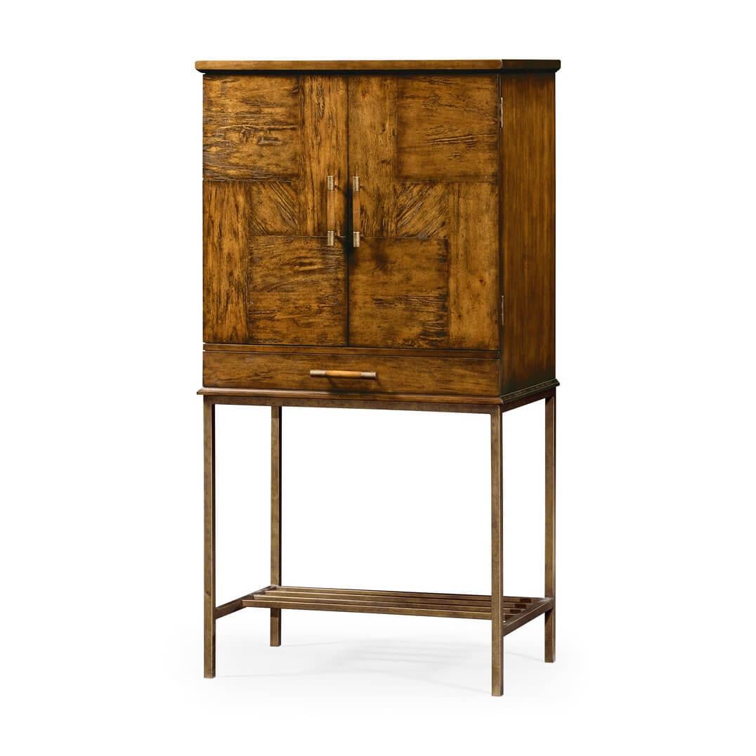 Modern country walnut bar cabinet or two-door drinks cabinet with a mirror back interior having a glass shelf and lighting, with a long frieze drawer and raised on a contemporary bronzed metal 'H' stretcher base.

Dimensions: 33 5/8