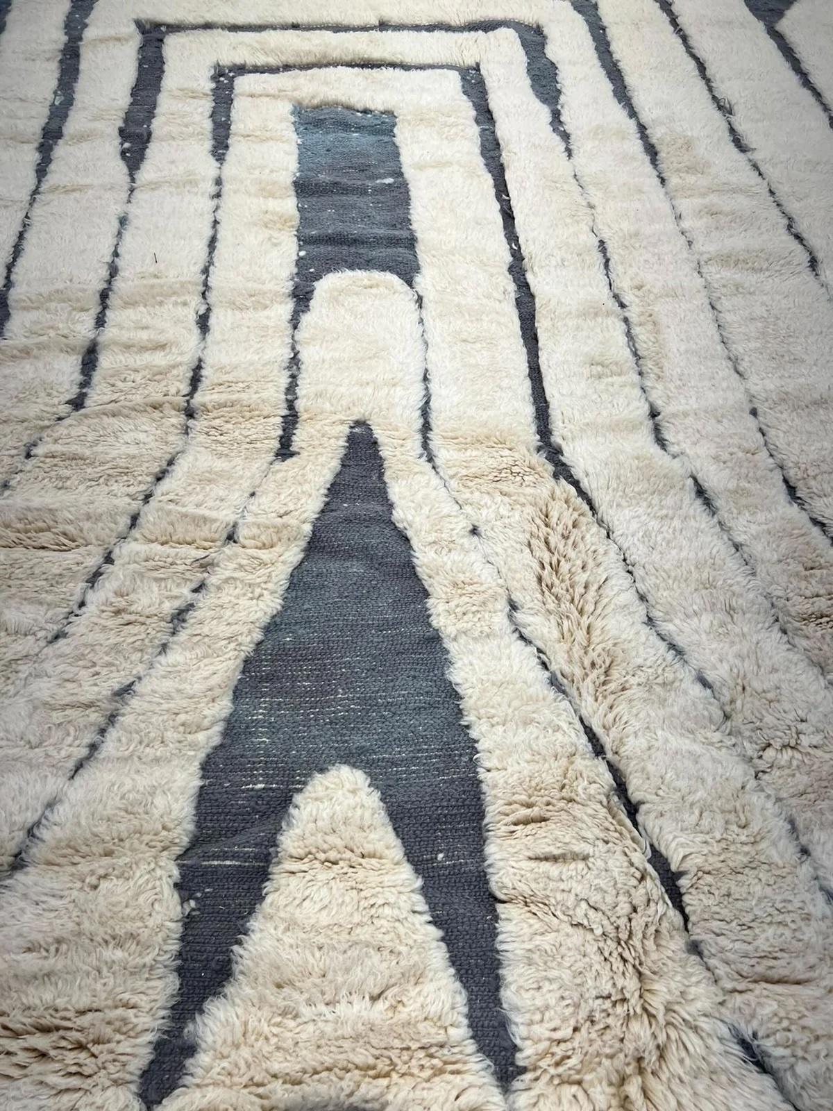 Questo grande tappeto marocchino color crema è stato realizzato a mano su un telaio tradizionale da abili artigiani nelle montagne dell'Atlante. È realizzato con lana M'Rirt, ultra lussuosa e di alta qualità. Si tratta di un perfetto pezzo neutro