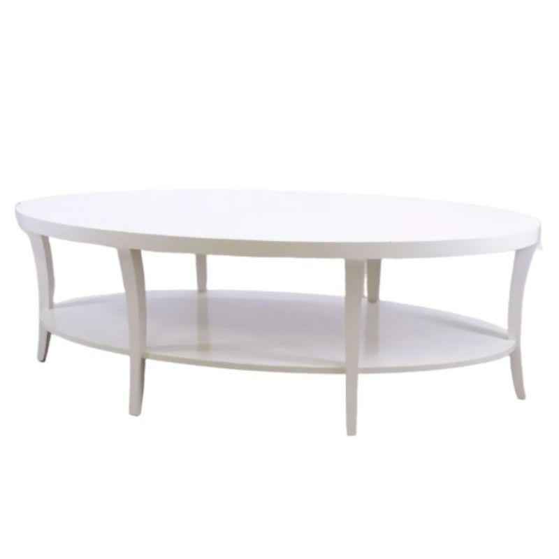 A vintage Century Furniture modern, lacquered, oval, two tiered, cream coffee table with six slender, shaped legs.