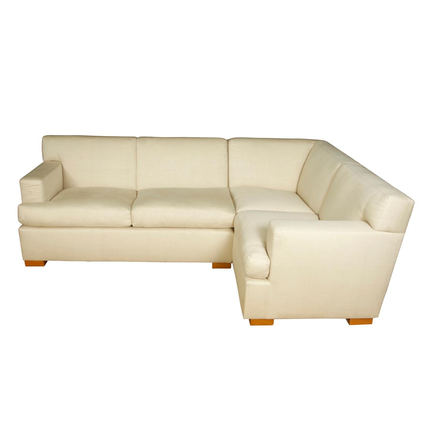 Modern cream linen sofa in sectional form comprised of two sections.