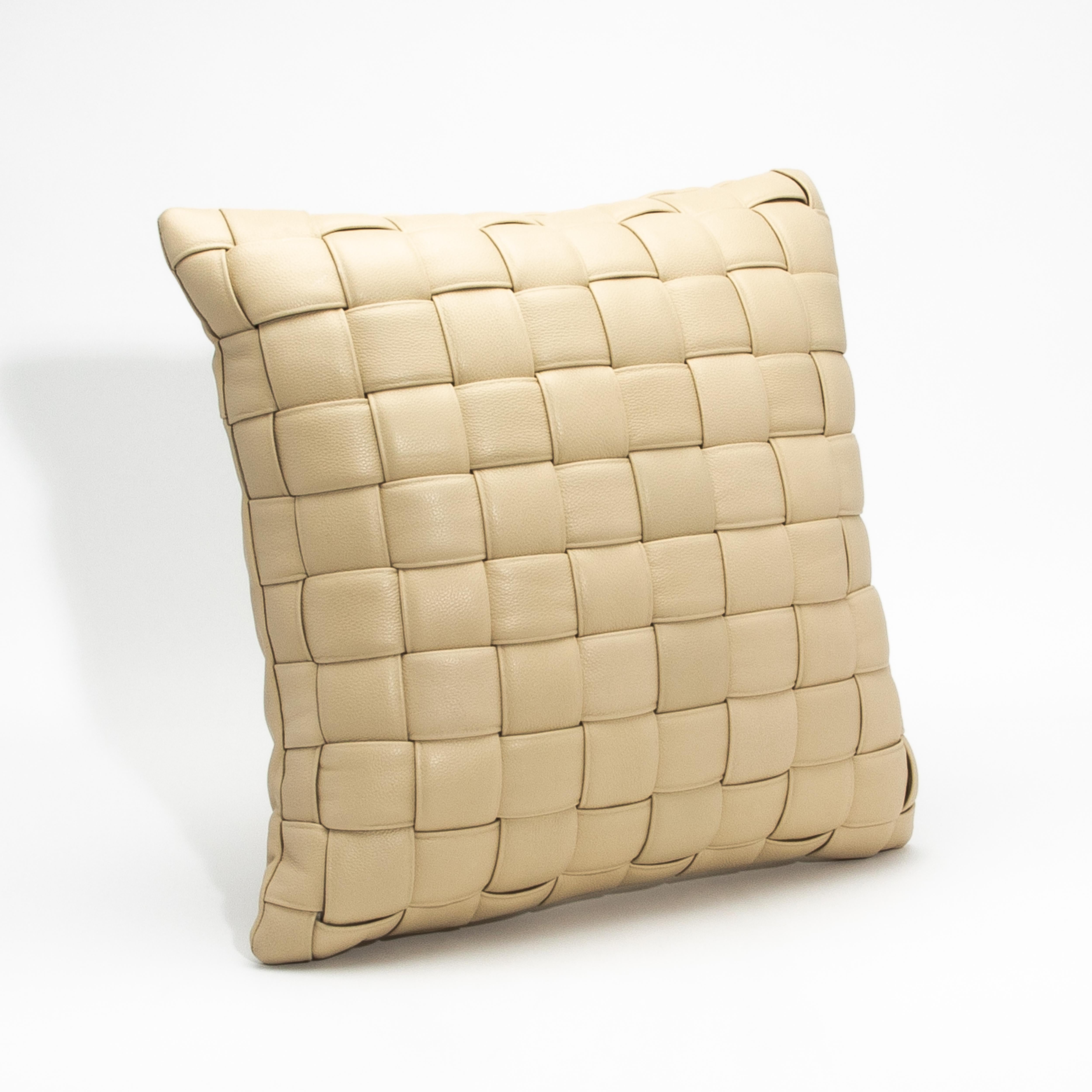 Dieses moderne cremefarbene Dekokissen aus gewebtem Leder ist ein raffiniertes Statement für modernen Luxus und strahlt zeitlose Eleganz und tadellose Handwerkskunst aus. Der weiche, cremefarbene Farbton unterstreicht die komplizierte Webtechnik des