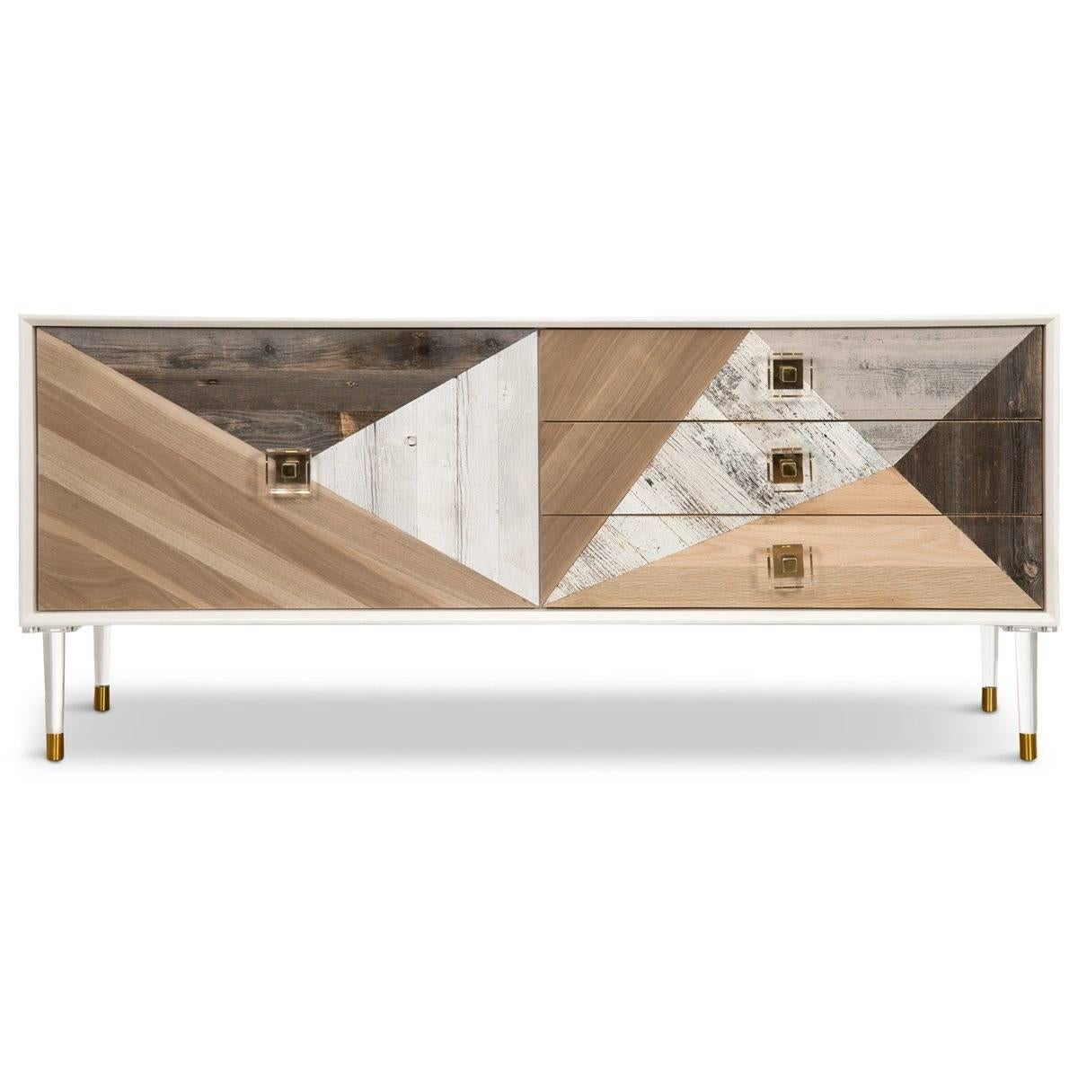 The Cape Town credenza is an industrial modernist's dream. This particular style features a mix of eight types of wood adorning it's one door and three drawers, each with Lucite and brass pulls, all atop matching tapered Lucite and brass legs. Its