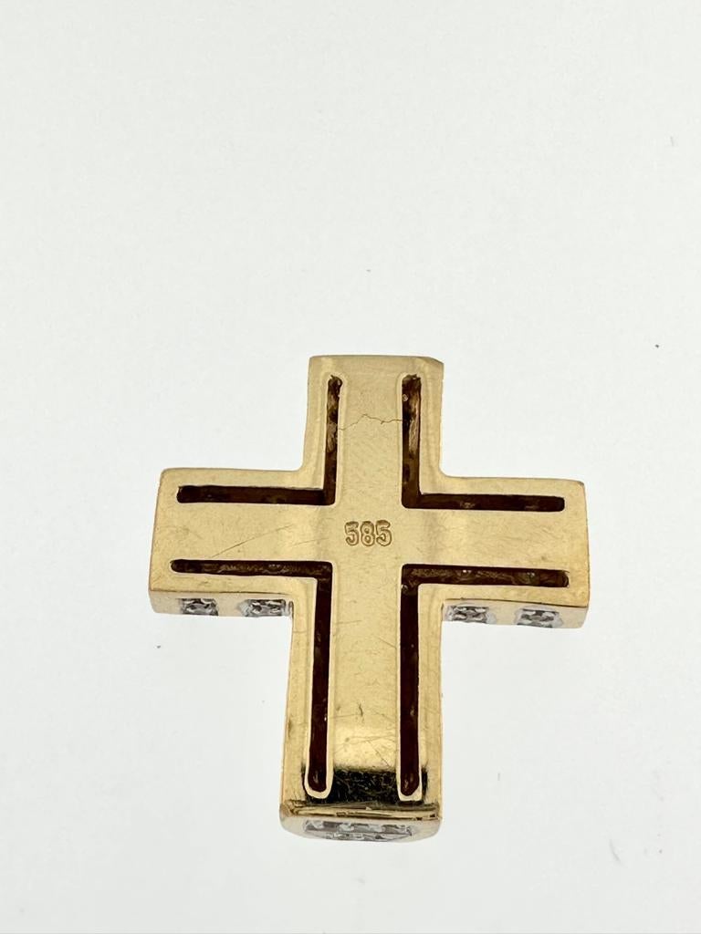 This Modern Cross in 14kt Yellow Gold is a striking piece of jewelry that blends contemporary design with timeless elegance. Crafted in Germany, this cross pendant features a dazzling array of diamonds that cover nearly the entire surface, creating