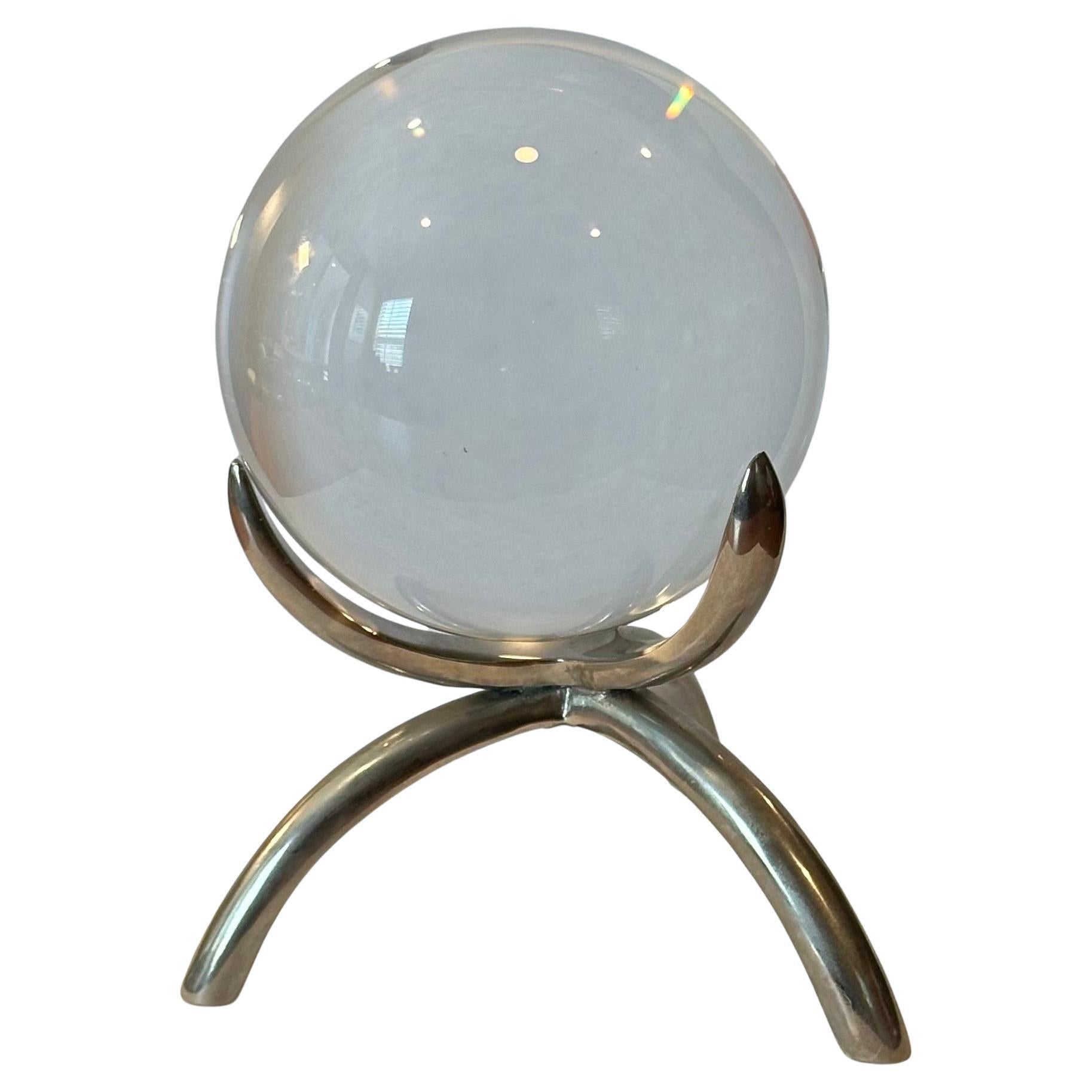 Sfera decorativa in cristallo su base in acciaio, circa anni '70. Il pezzo è in ottime condizioni, senza scheggiature o crepe; ha una bella finitura lucida con tre supporti sulla base per tenere la sfera in posizione.  La sfera misura 4 
