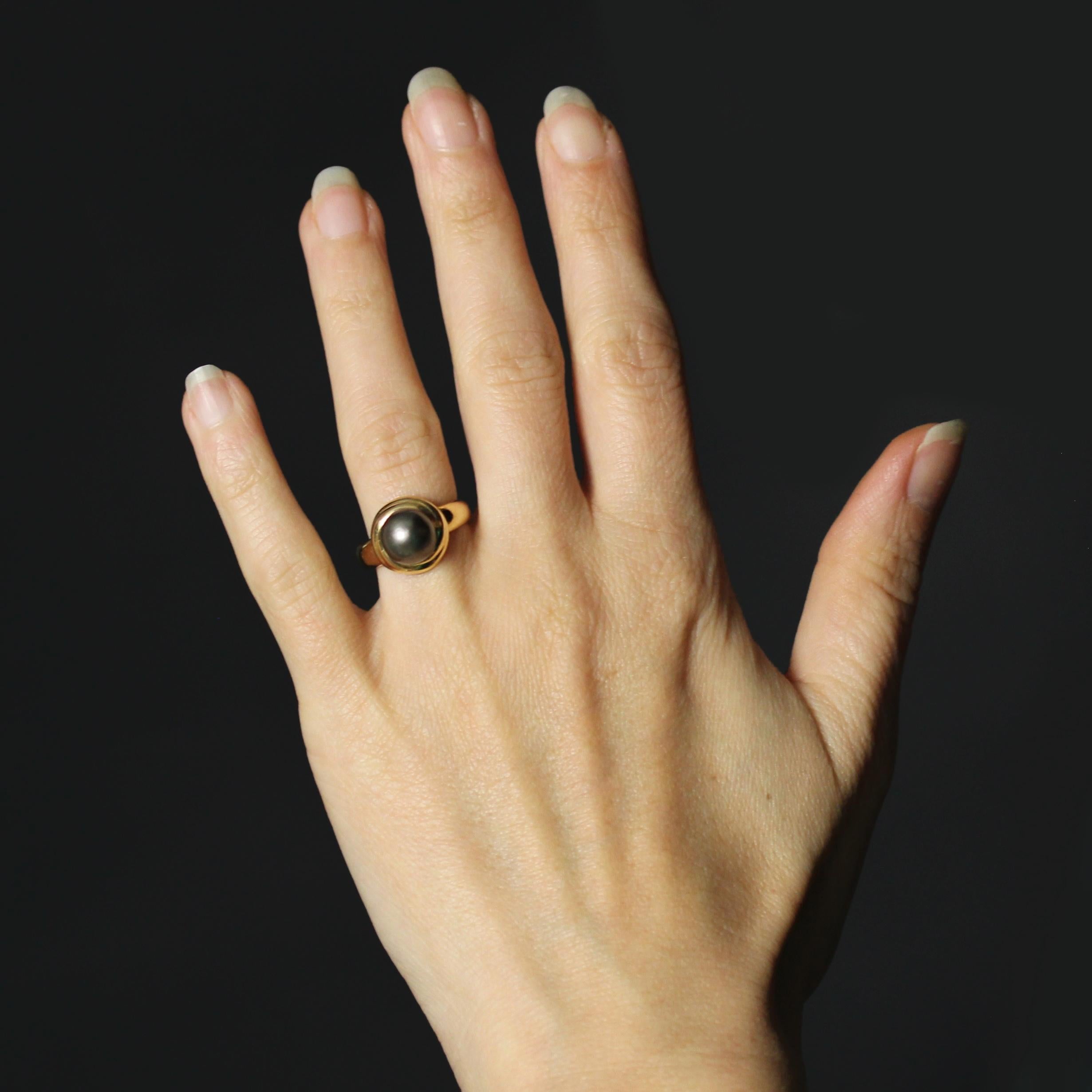 Anello in oro giallo 18 carati, punzone a testa d'aquila.
Questo anello con perla grigia di seconda mano presenta un'ampia fascia con un motivo a gadroon rotondo nella parte superiore, ornato al centro da una perla coltivata color grigio