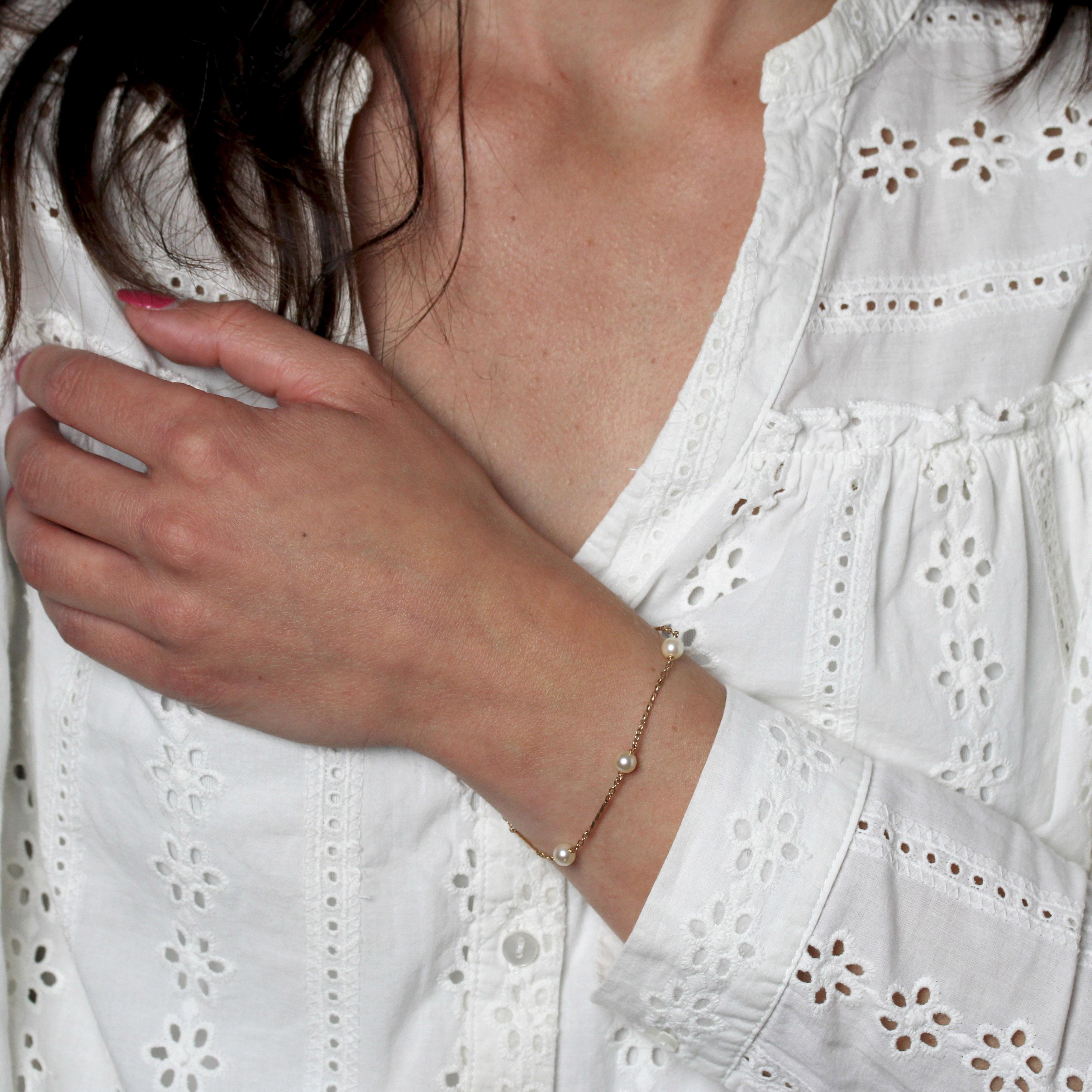 Bracciale in oro rosa 18 carati, marchio di fabbrica con testa d'aquila.
Un raffinato bracciale di perle, che forma una maglia forçat punteggiata da motivi d'oro ritorti e da 5 perle coltivate. La chiusura è a molla.
Diametro delle perle: 5/5,5 mm