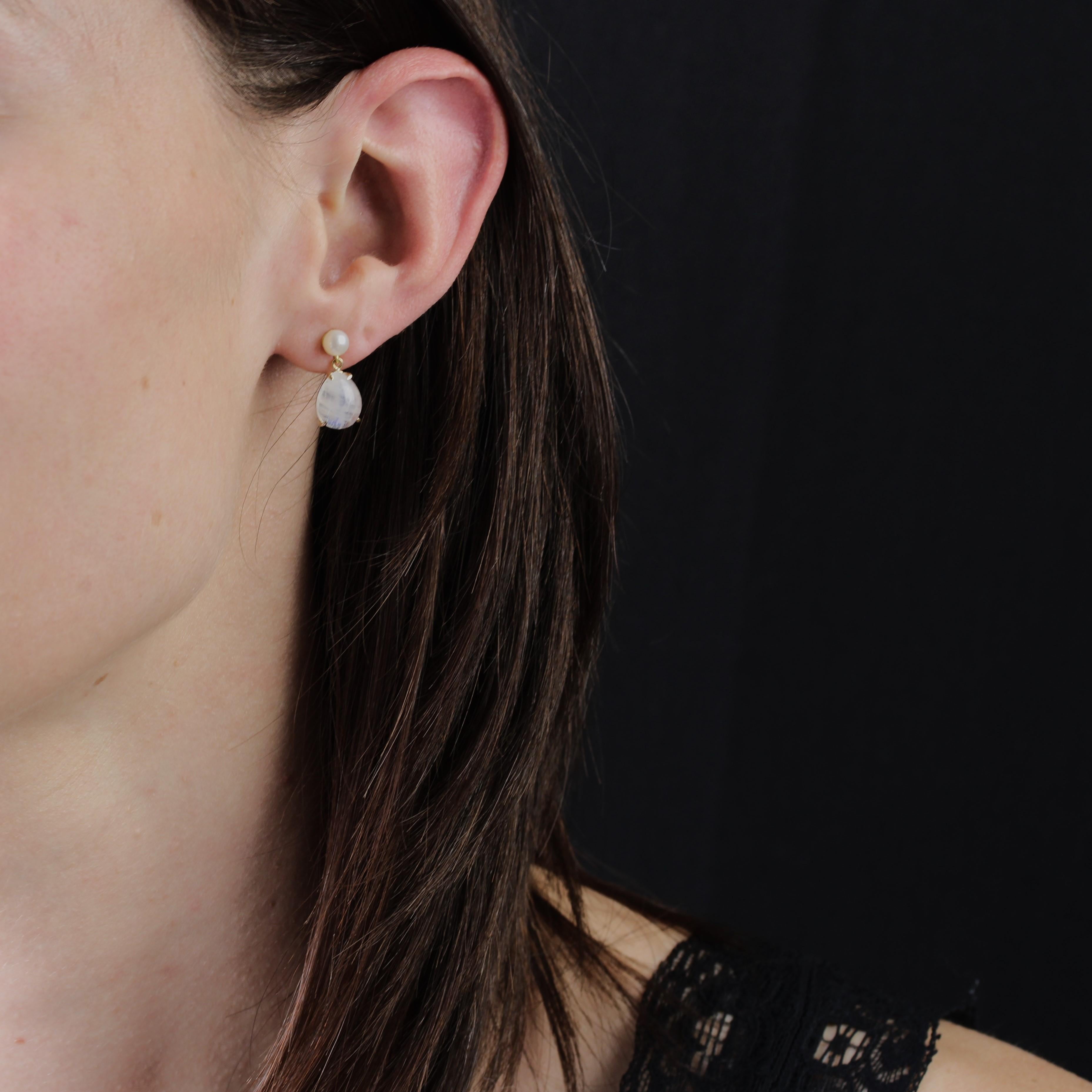 For pierced ears.
Earrings in 18 karat yellow gold.
Each earring features a pearly white oriental button pearl holding a claw-set pear-shaped cabochon moonstone. The clasp is a butterfly.
Diameter of the pearls : 4/4,5 mm approximately.
Height : 1.5