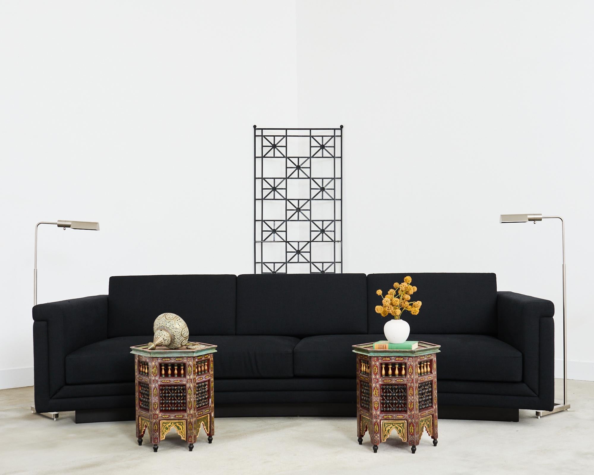 Dramatic bespoke modern sofa custom upholstered in a black linen fabric. The angular sofa features a concave or curved front in the style and manner of Edward Wormley for Dunbar. The sofa has a floating design mounted on a four inch high hidden