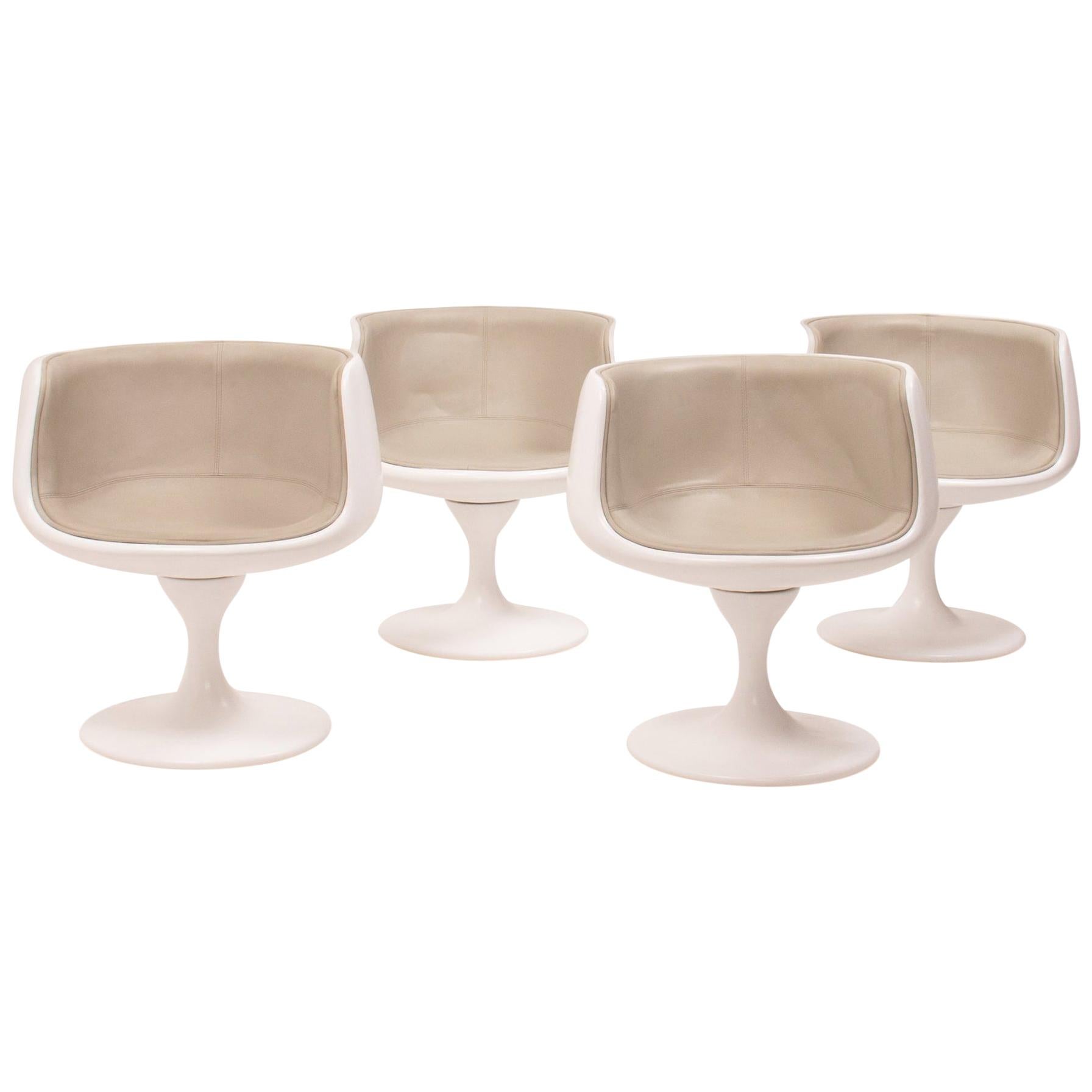 This set of four modern curved swivel tulip tub chairs have a sleek, modernist aesthetic and feature the iconic ‘tulip’ style base originally designed by Eero Saarinen. 

The chairs have moulded curved white shells, which have been newly