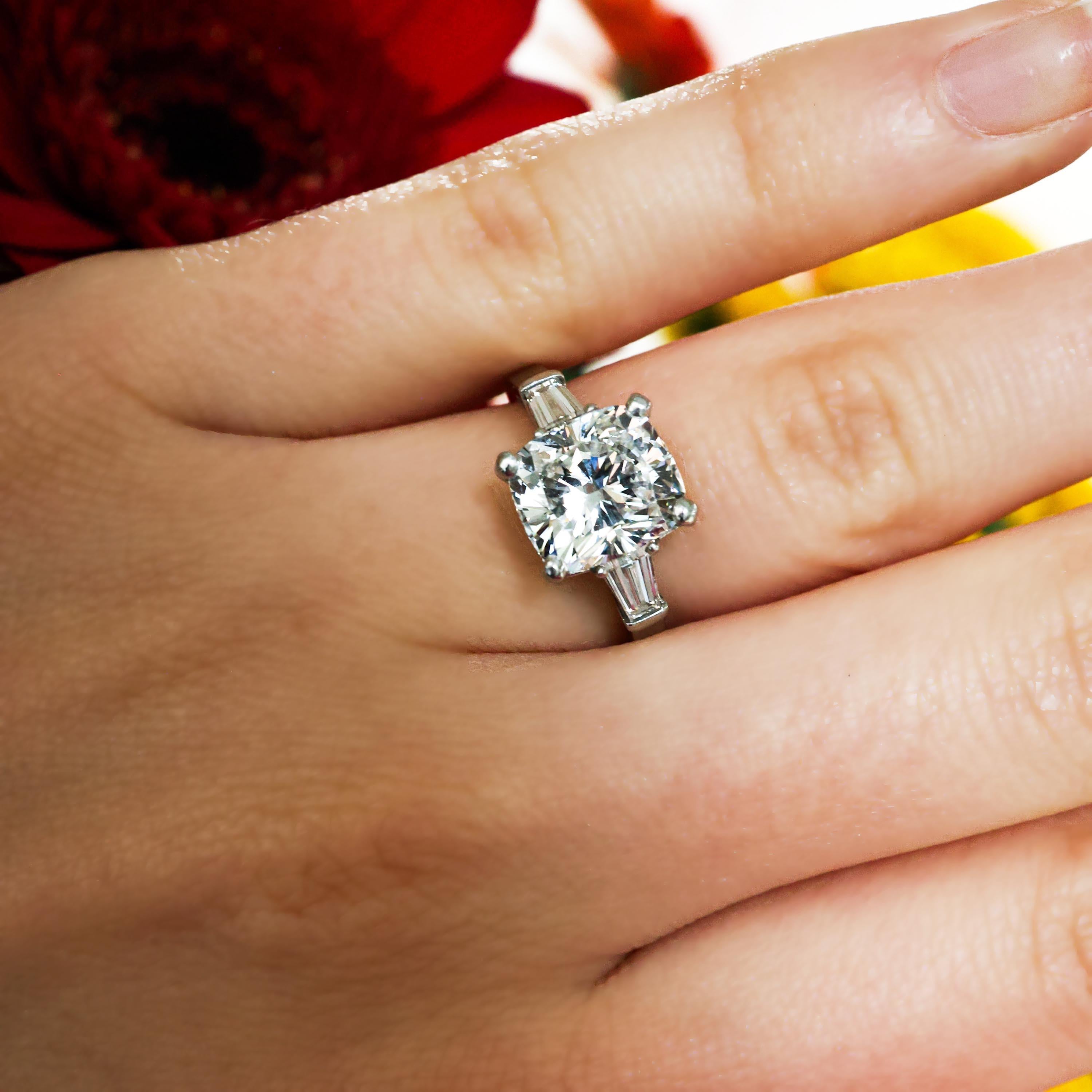 Bague moderne en diamant taille coussin, avec un diamant taille coussin de couleur G, pureté VS1, pesant 3,01 carats, dans une monture à quatre griffes, avec un diamant taille baguette effilé serti dans chaque épaule, dans une tige à épaulement