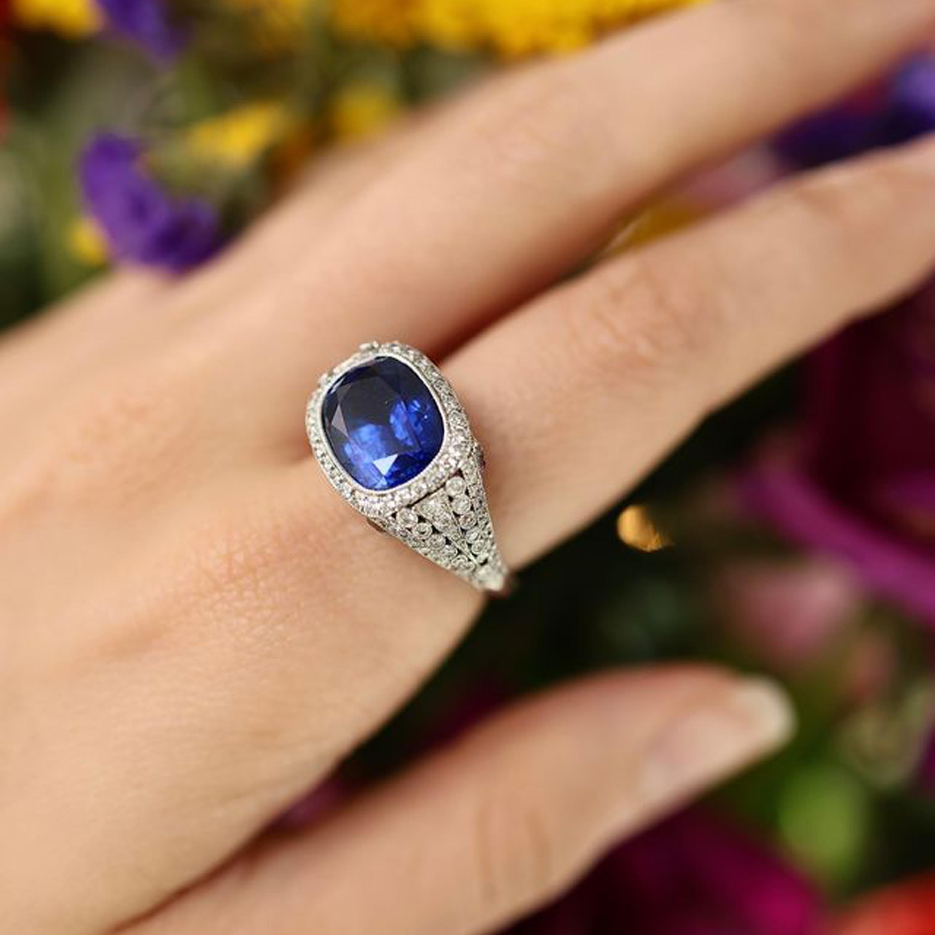 Anillo de zafiro y diamantes engastado con un zafiro talla cojín de 8,64 ct en el centro, con diamantes engastados en el contorno, los hombros y el bisel y con zafiros talla calibré engastados alrededor del bisel del dedo, montado en platino. Con un