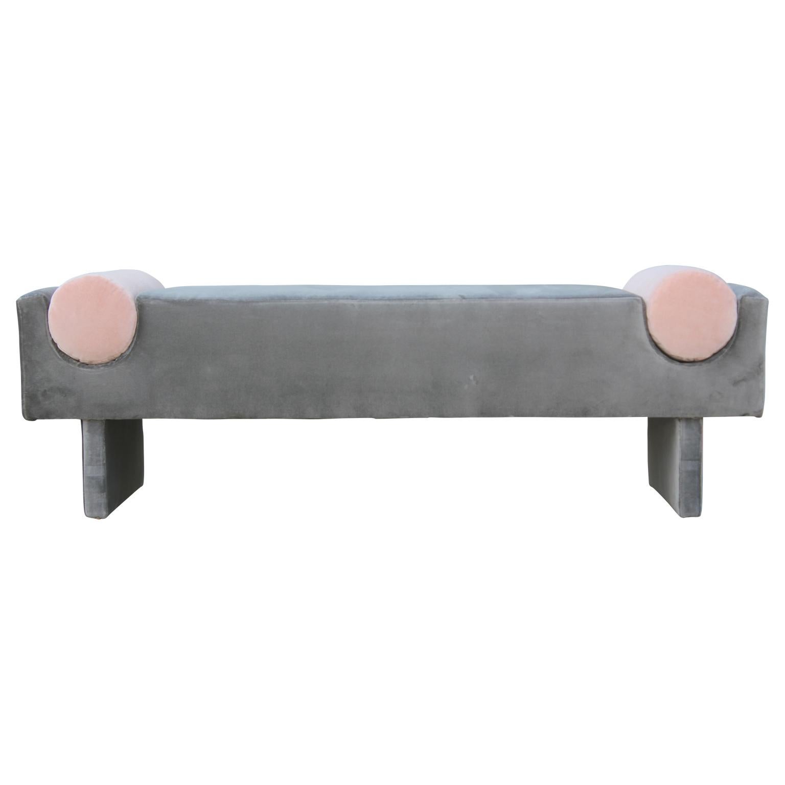 Custom-made rectangular bench upholstered in a lush grey velvet and attached bolster accents upholstered in a lovely light pink velvet.