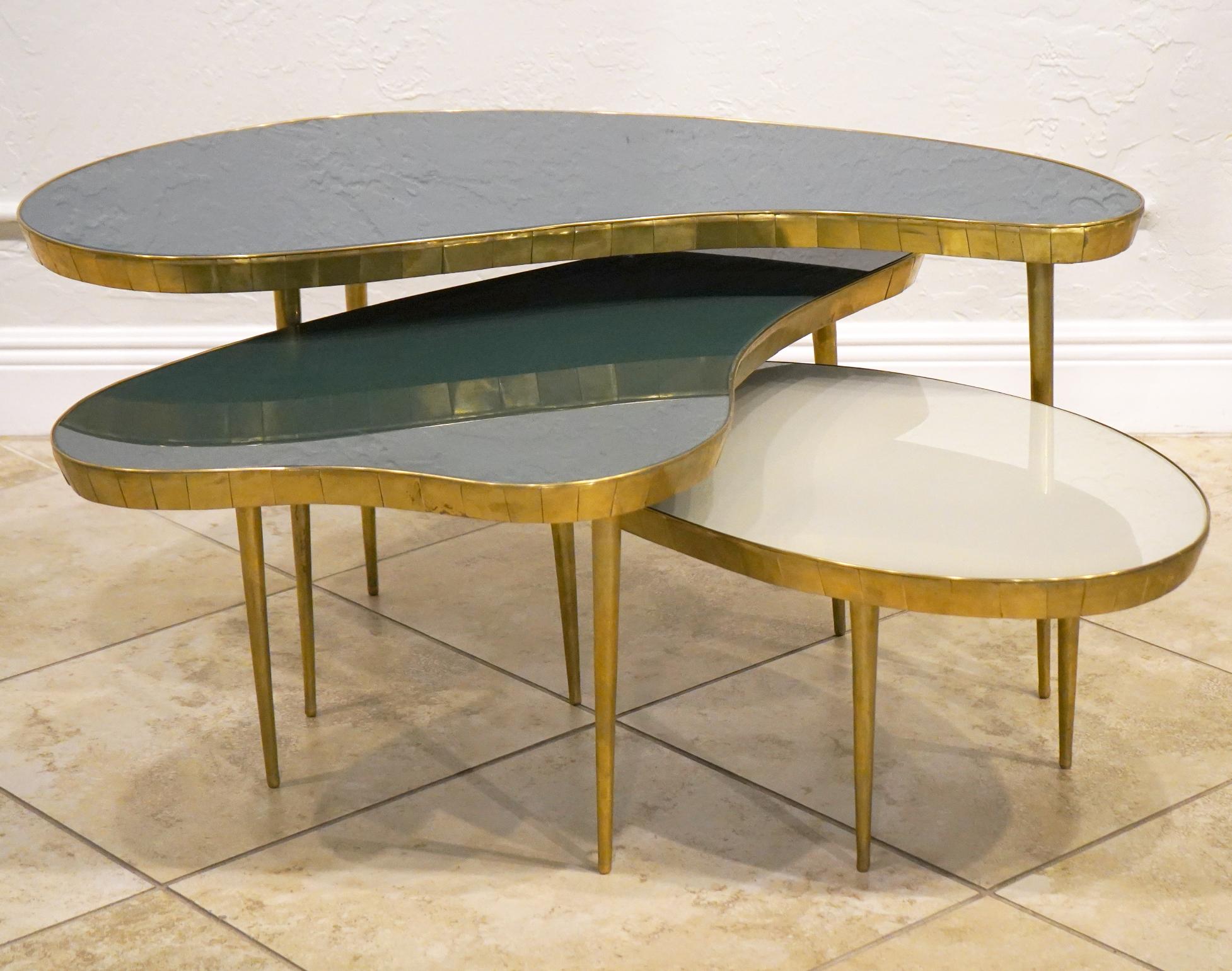 Unique set of Italian brass and glass stacking tables. Can be arranged in different directions to create a fun and interesting look. Each table gets gradually smaller and has different colored glass tops.