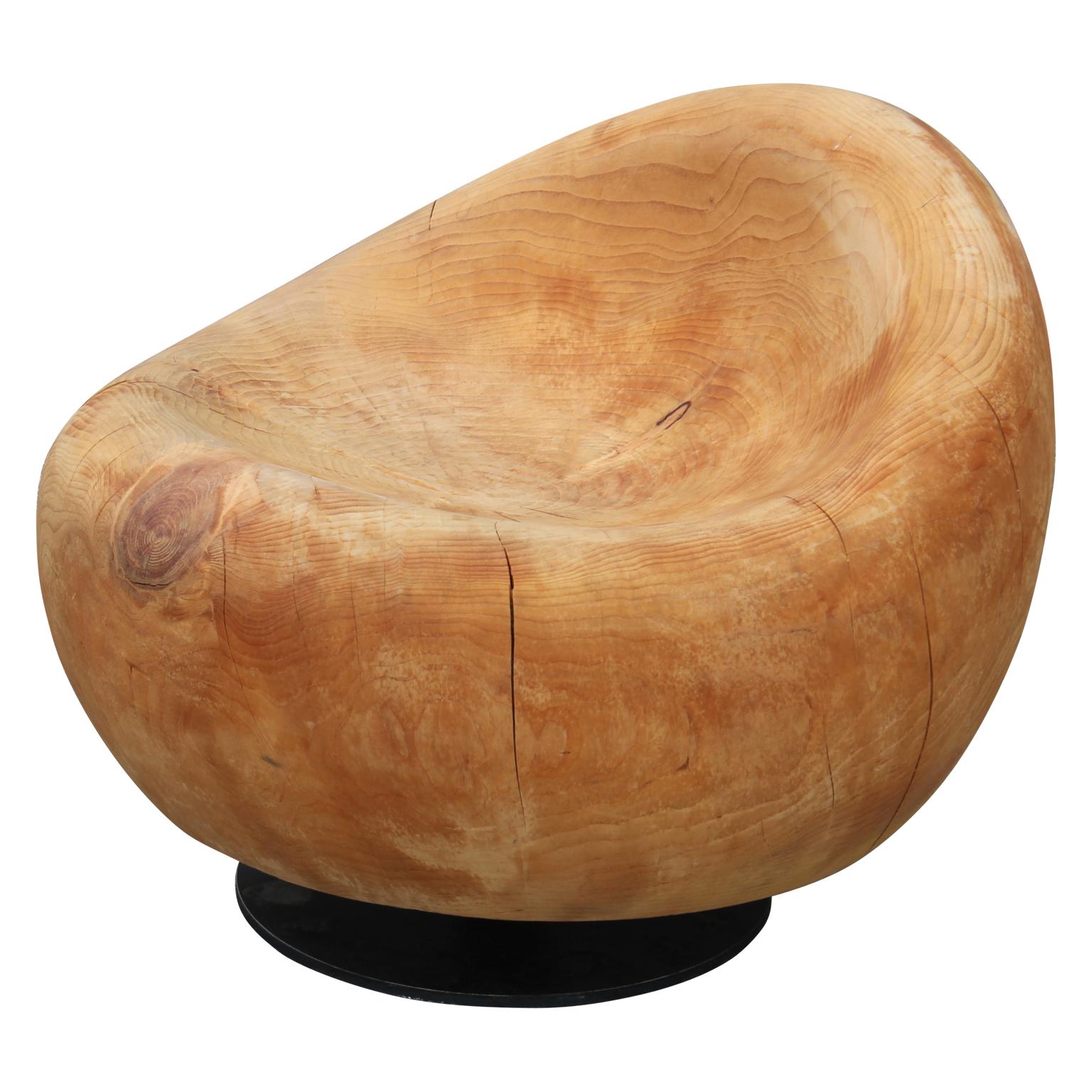 Modern unique custom egg shaped swivel lounge chair or slipper chair. Carved out of one solid piece of pine wood with a steel base.