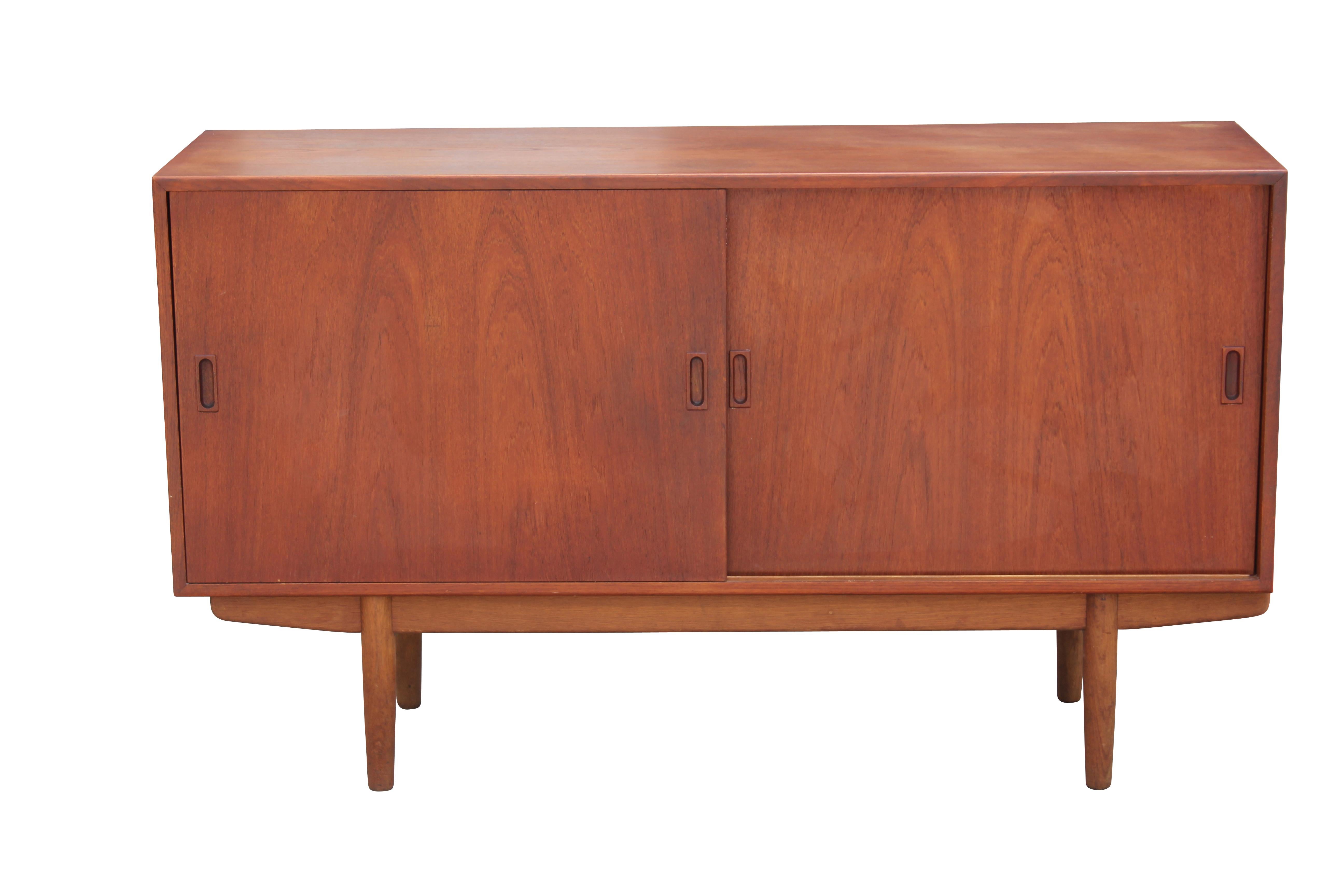 Gorgeous Danish modern sliding door credenza or sideboard by Børge Mogensen. The sliding doors open to reveal shelving on the left and four drawers on the right.