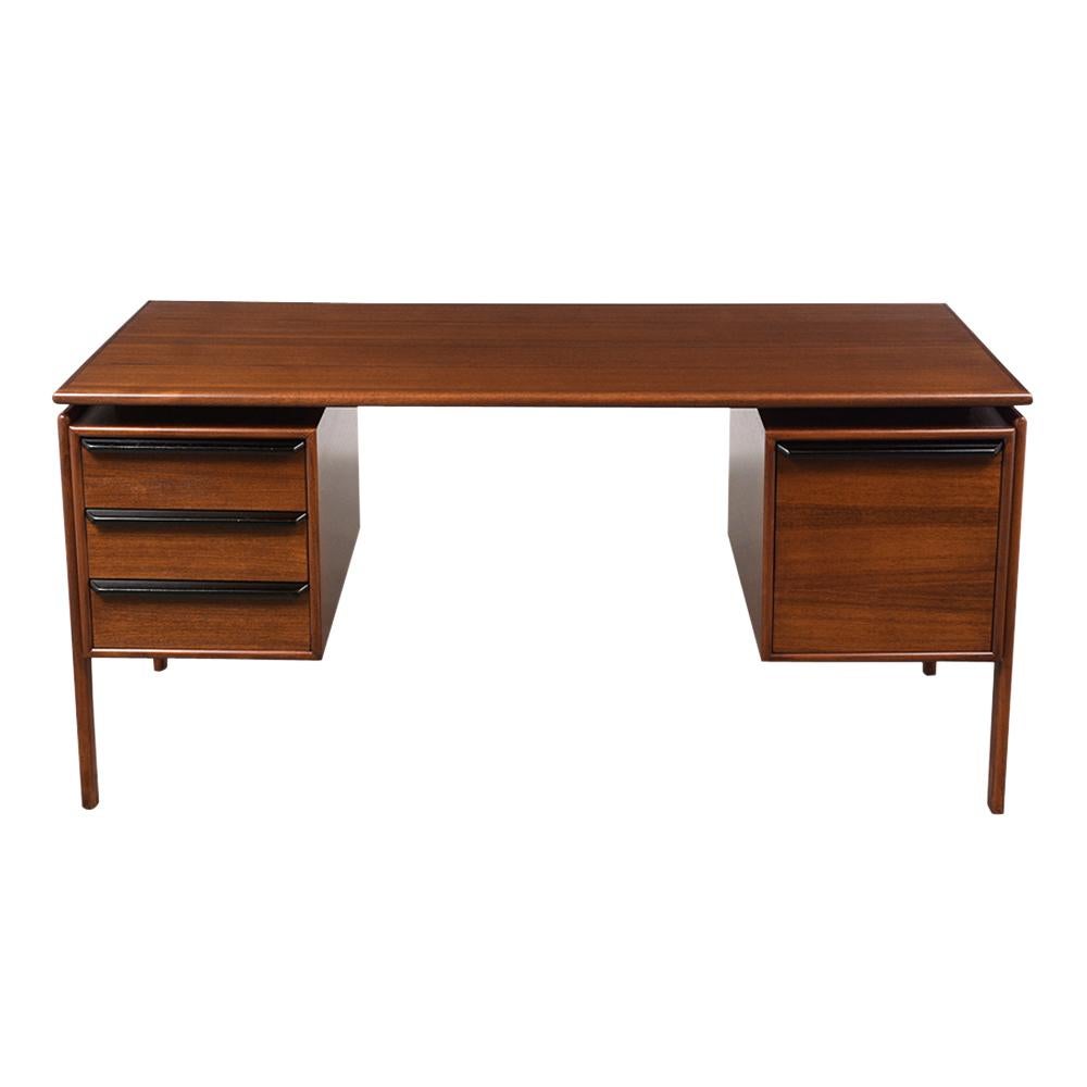 This 1960s Mid-Century Modern floating desk is made out of teak wood stained dark walnut and ebonized combination with a lacquered finish. It has four drawers with large carved wood handles stained a black. This desk is supported by a set of