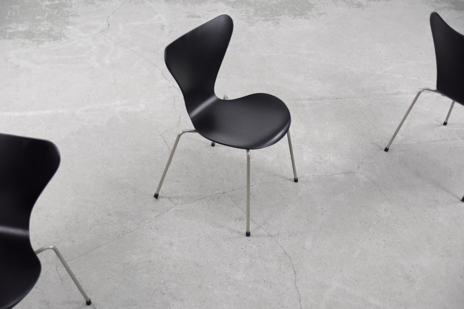 This set of four Series 7 chairs was designed in 1955 by Arne Jacobsen for the Danish manufacture Fritz Hansen. This is an early production from the second half of the 1950s. The chairs have signatures used in the 1950s. Their exceptional shape is