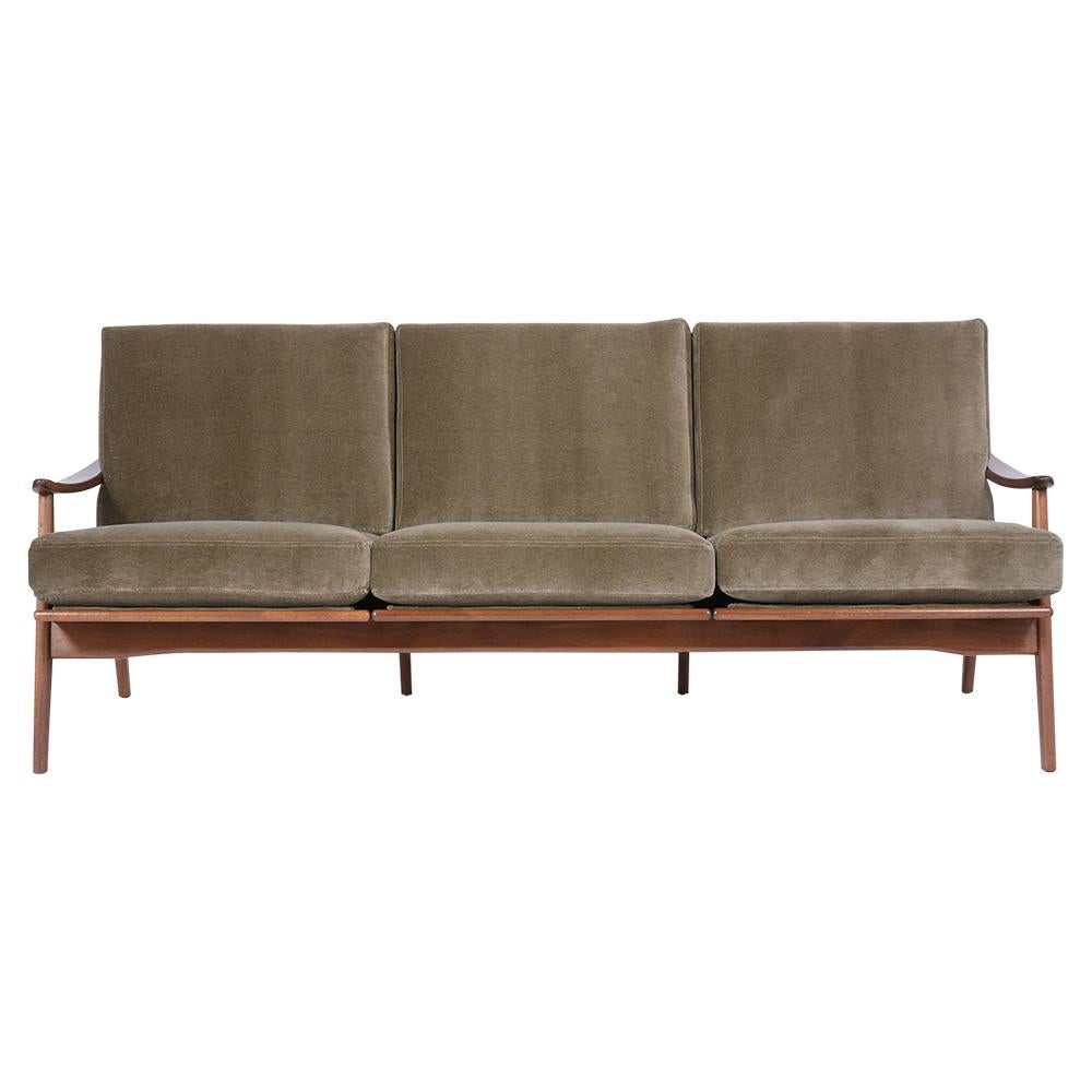 An extraordinary danish modern sofa handcrafted out of walnut wood with a newly stained lacquered finish and is professionally restored. This sofa features sculpted slatted backrests, paddle-shaped armrests, and has been newly upholstered in