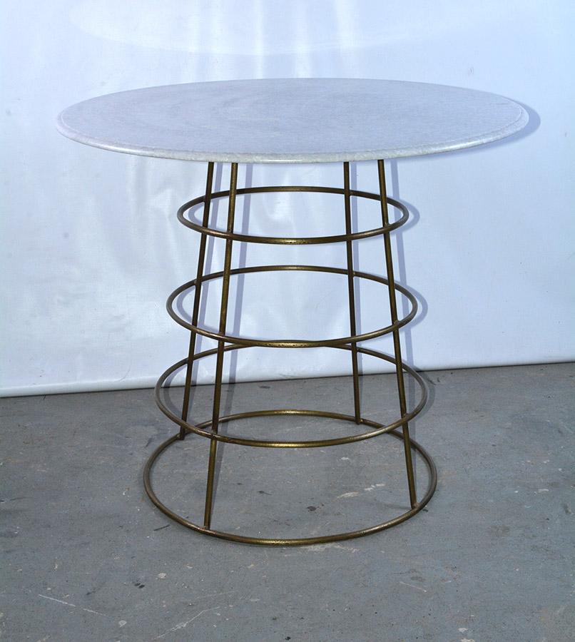 Stylish gilt metal bistro or pub table with white marble top has a metal base with 4 graduated rings. Table can work well in a modern, traditional or casual setting. Can be used indoors or outdoors. Garden, porch or poolside patio table.