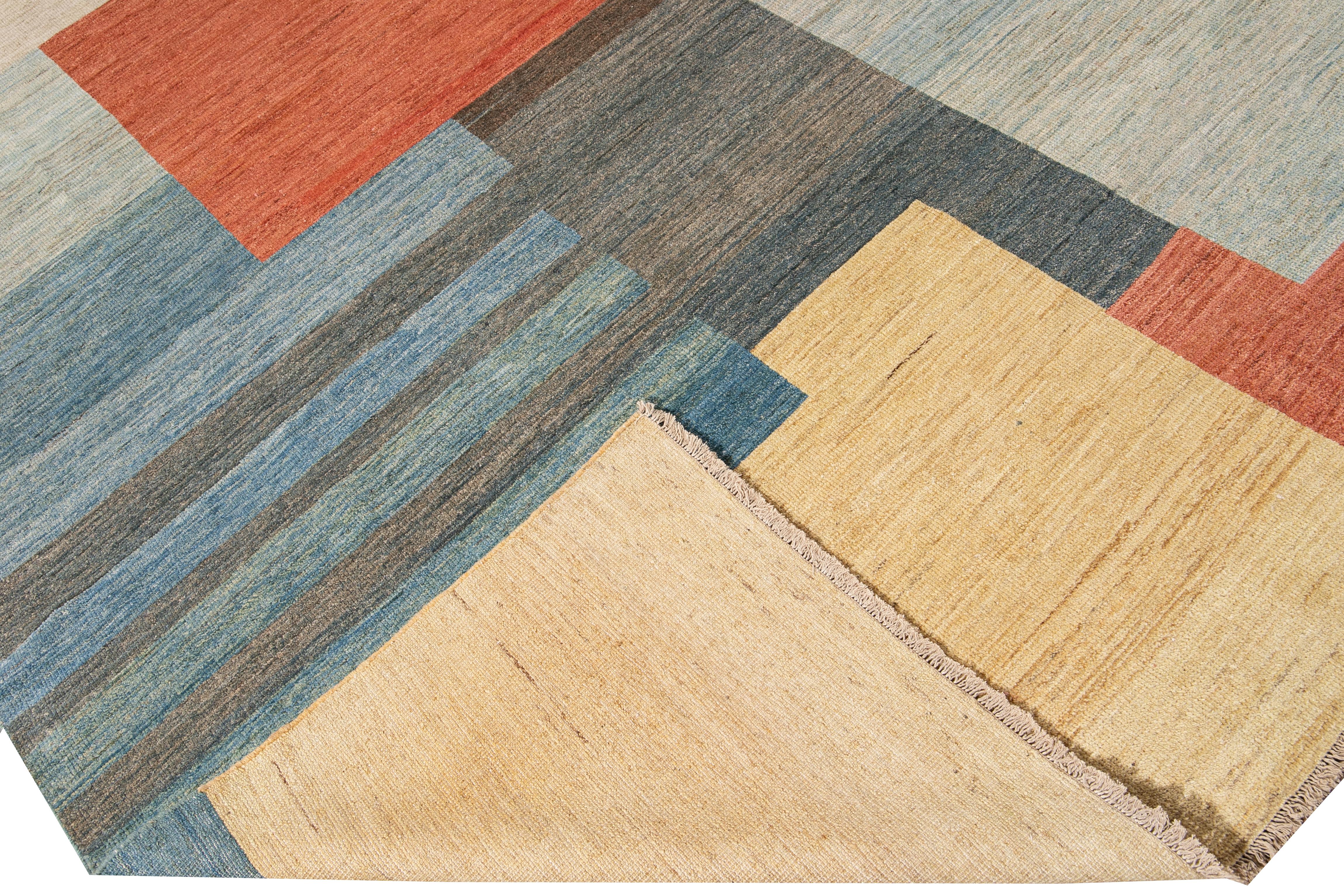 Bellissimo tappeto moderno in lana annodato a mano in stile Art Déco con un campo beige, blu, marrone e arancione in uno splendido disegno geometrico astratto all-over.

Questo tappeto misura: 9'11