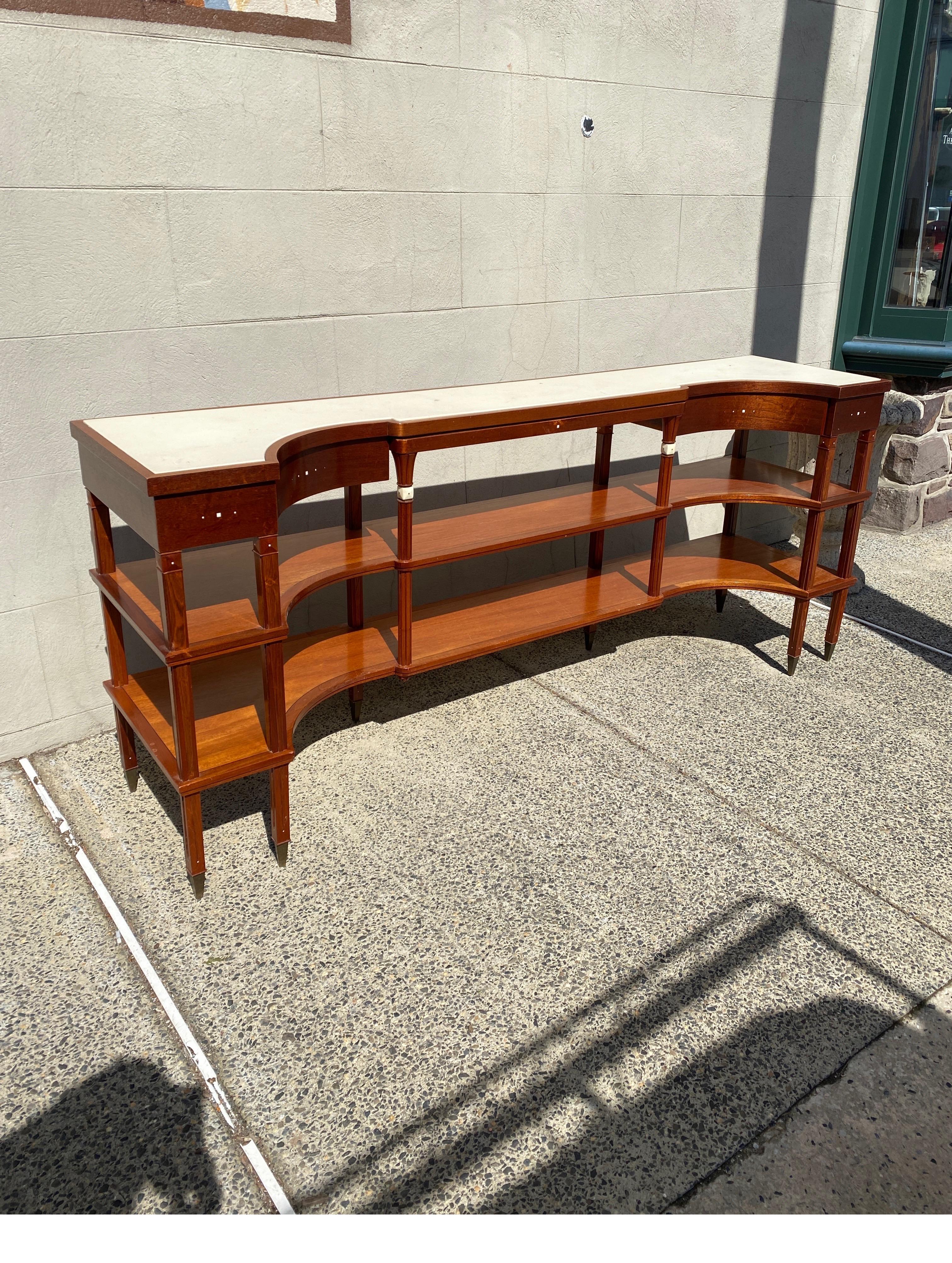 A stylish Modern Art Deco style open shelved console or sideboard. the concave form with a drawer on each side with a center slide out shelf. The top and inside of the drawers with ivory color leather with inlays of bone on the front surface and on