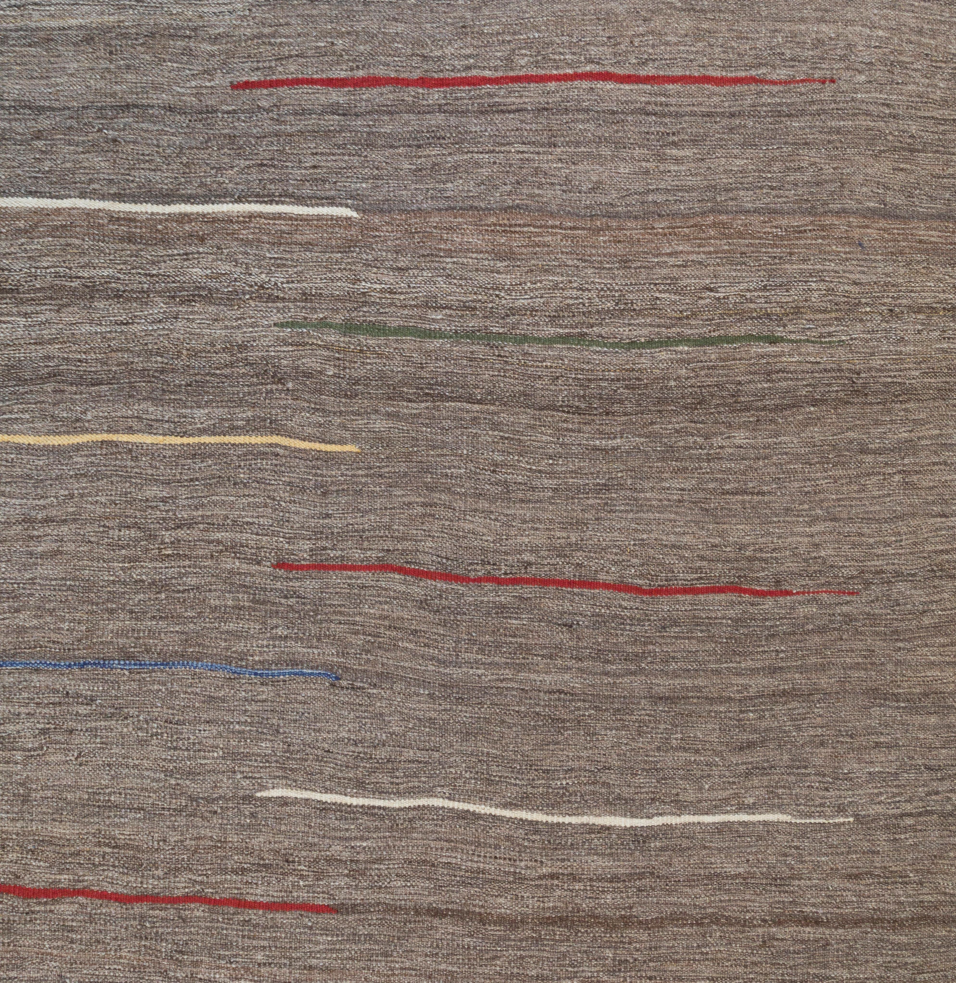 Ce tapis moderne à tissage plat de couleur moka est composé à 100 % de laine persane non teintée filée à la main. Il s'inspire des kilims vintage originaires de la région de Shiraz en Iran. Nasiri perpétue sa riche tradition de fabrication de tapis