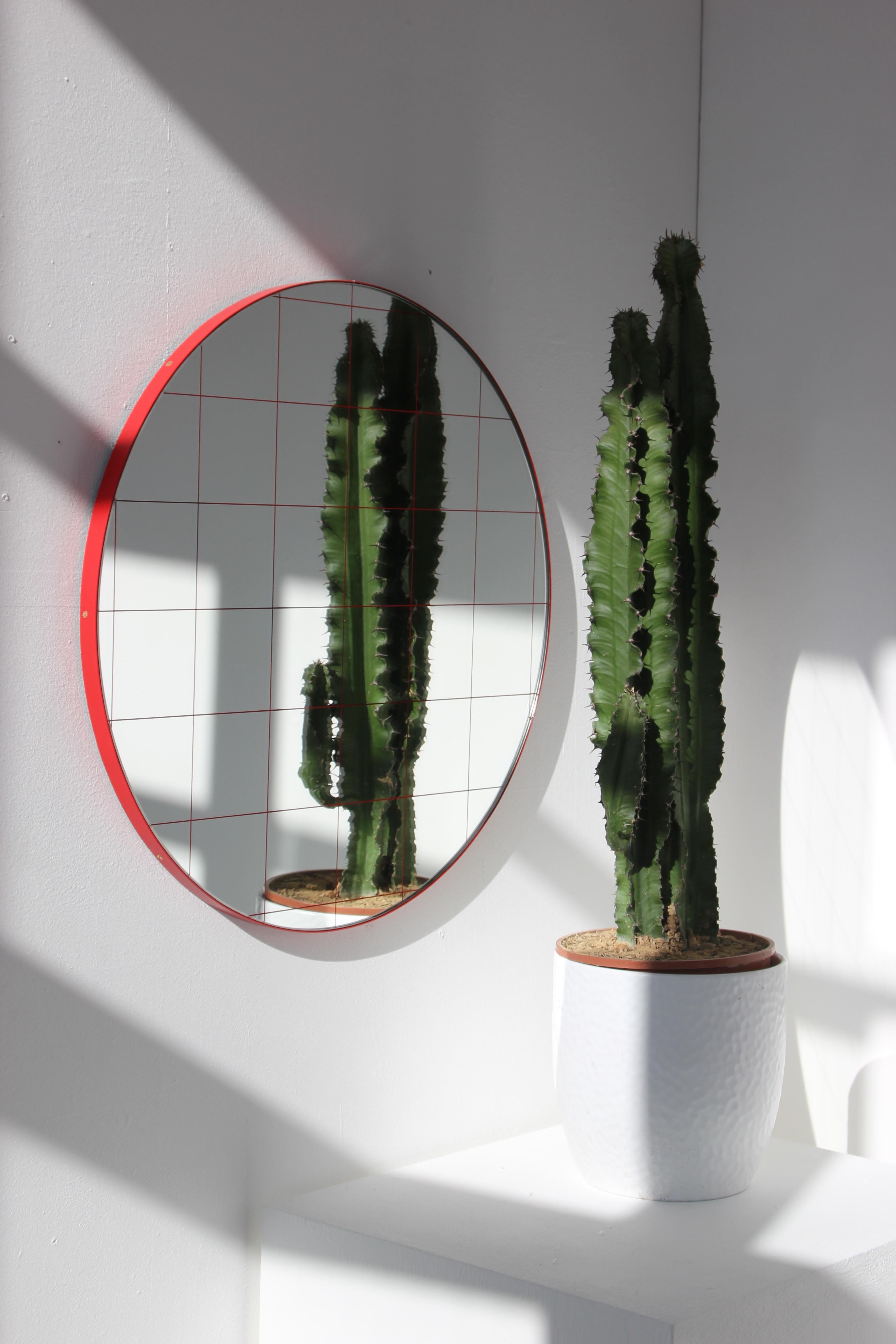 Modern decorative round Orbis mirror with a red grid and a powder coated red frame. Designed and handcrafted in London, UK.

All mirrors are fitted with an ingenious French cleat (split batten) system so they may hang flush with the wall in four