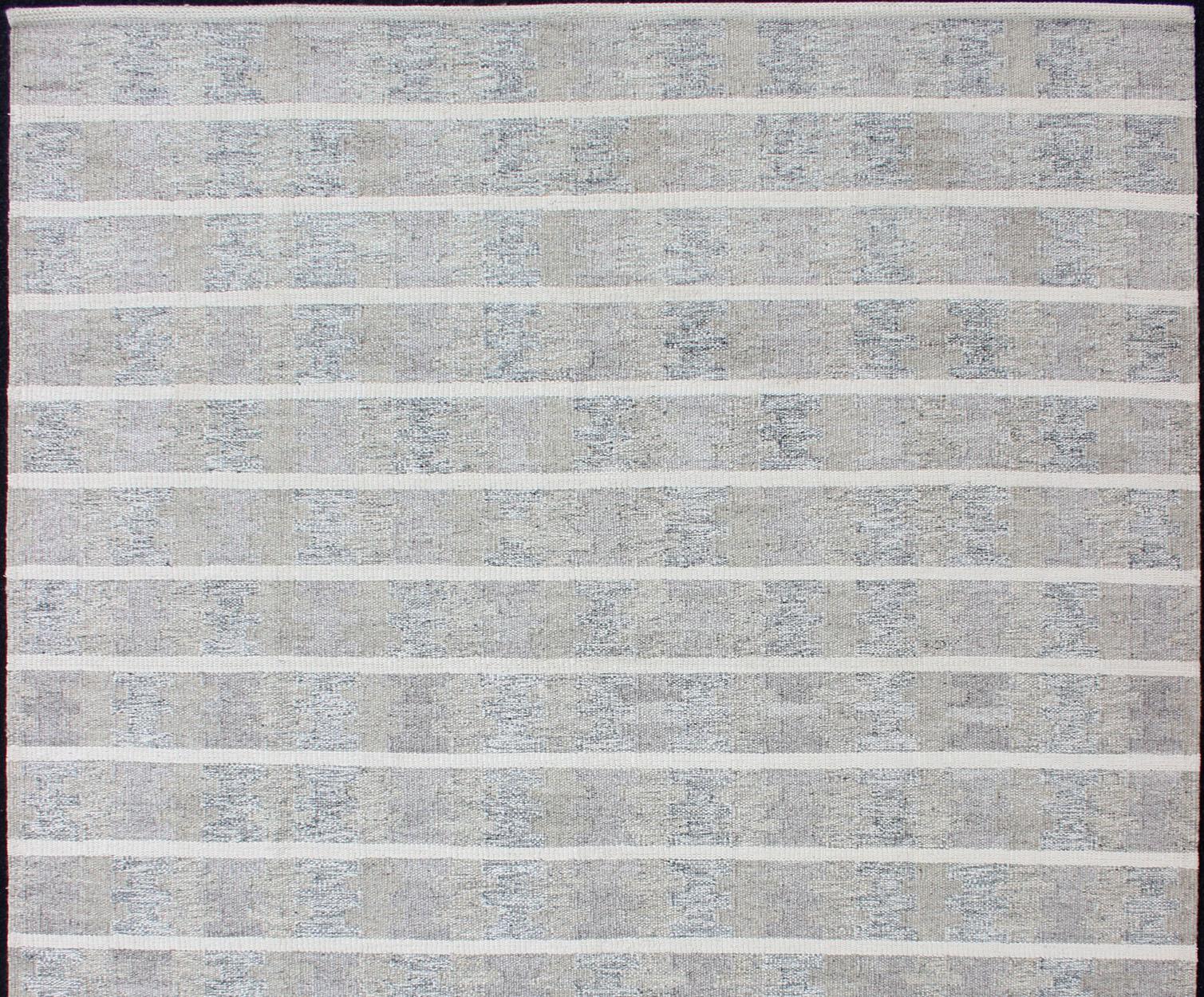 Con le sue linee a righe, questo tappeto scandinavo a tessitura piatta dai colori neutri è adatto a interni moderni, tappeto KHN-1027-SW-102, paese d'origine/tipo: Scandinavia / Moderno scandinavo

Questo tappeto a trama piatta dal design