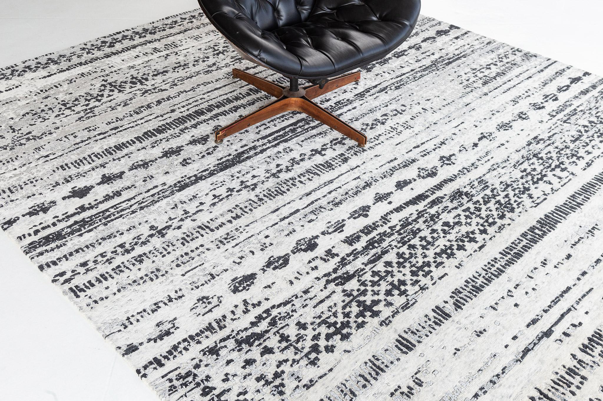 This a wool and cotton rug in a horizontal stroke pattern with motifs over a contrast of jet and white. A contemporary and minimalist interior is a match for your modern room spaces. A centerpiece that will amaze your guests.

Rug