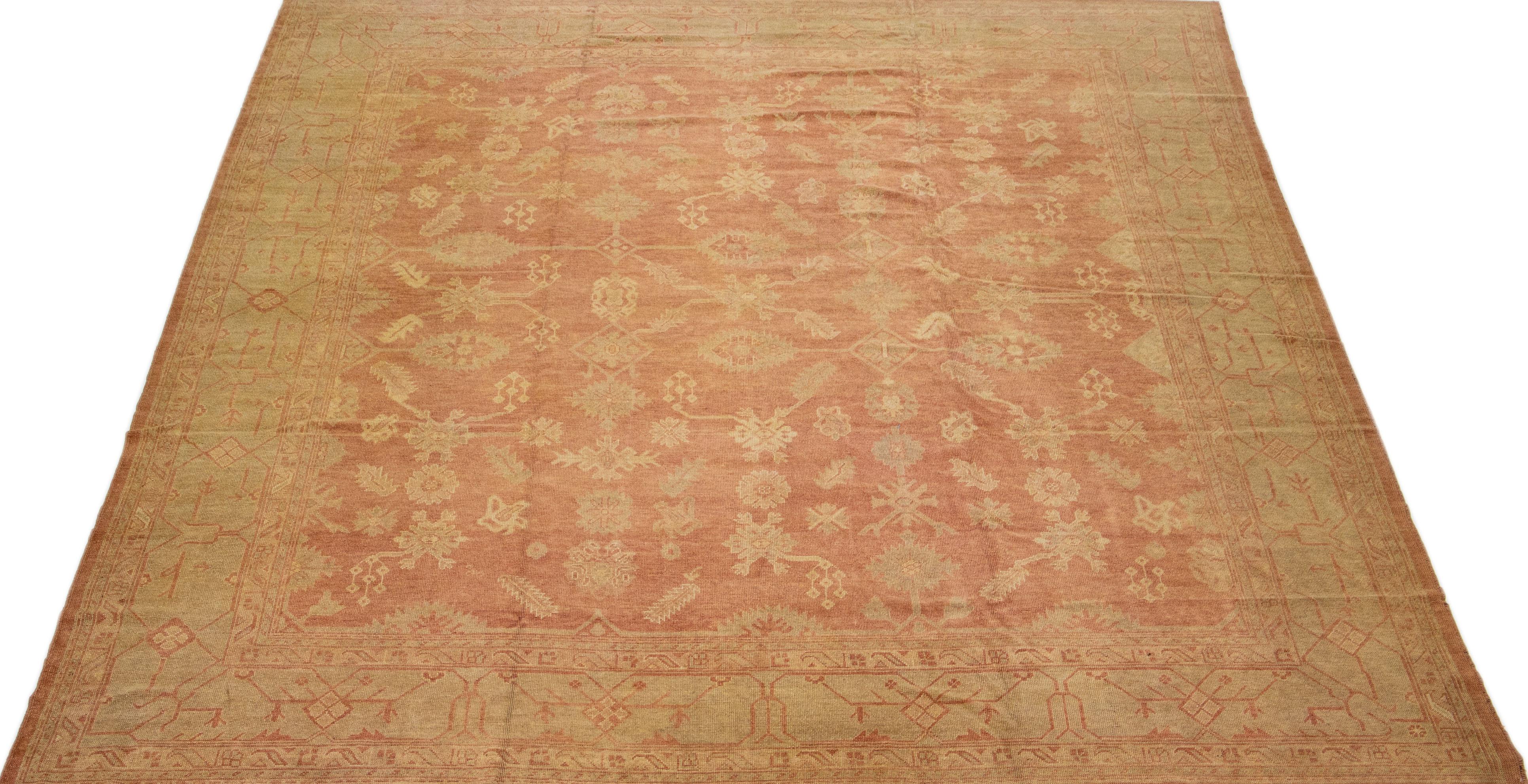 Beautiful modern Turkish Oushak hand-knotted wool rug with a light rust-orange color field. This rug has gray accents in a gorgeous large-scale floral motif.

This rug measures: 13'10