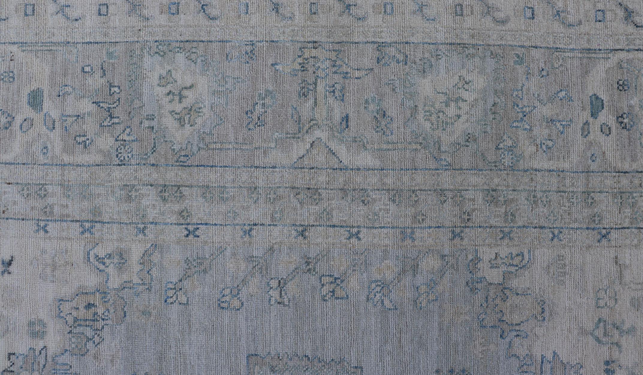 Moderner, entworfener Teppich mit hellblauem Hintergrund und Stammesmedaillon-Motiven (Handgeknüpft) im Angebot