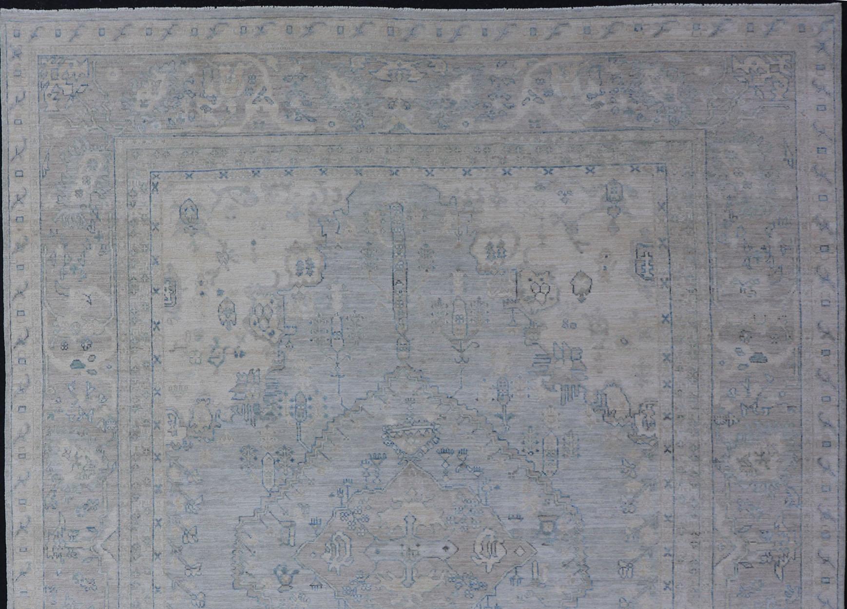 Moderner, entworfener Teppich mit hellblauem Hintergrund und Stammesmedaillon-Motiven im Angebot 1