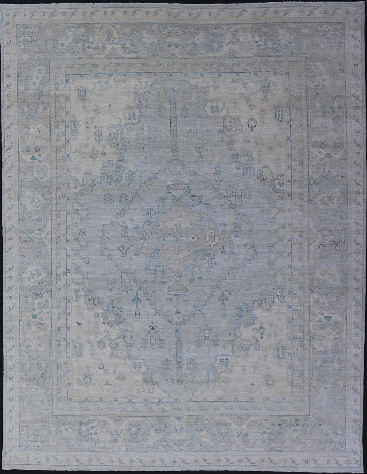 Tapis moderne à fond bleu clair et motifs de médaillons tribaux