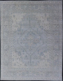 Alfombra de diseño moderno con fondo azul claro y motivos de medallones tribales