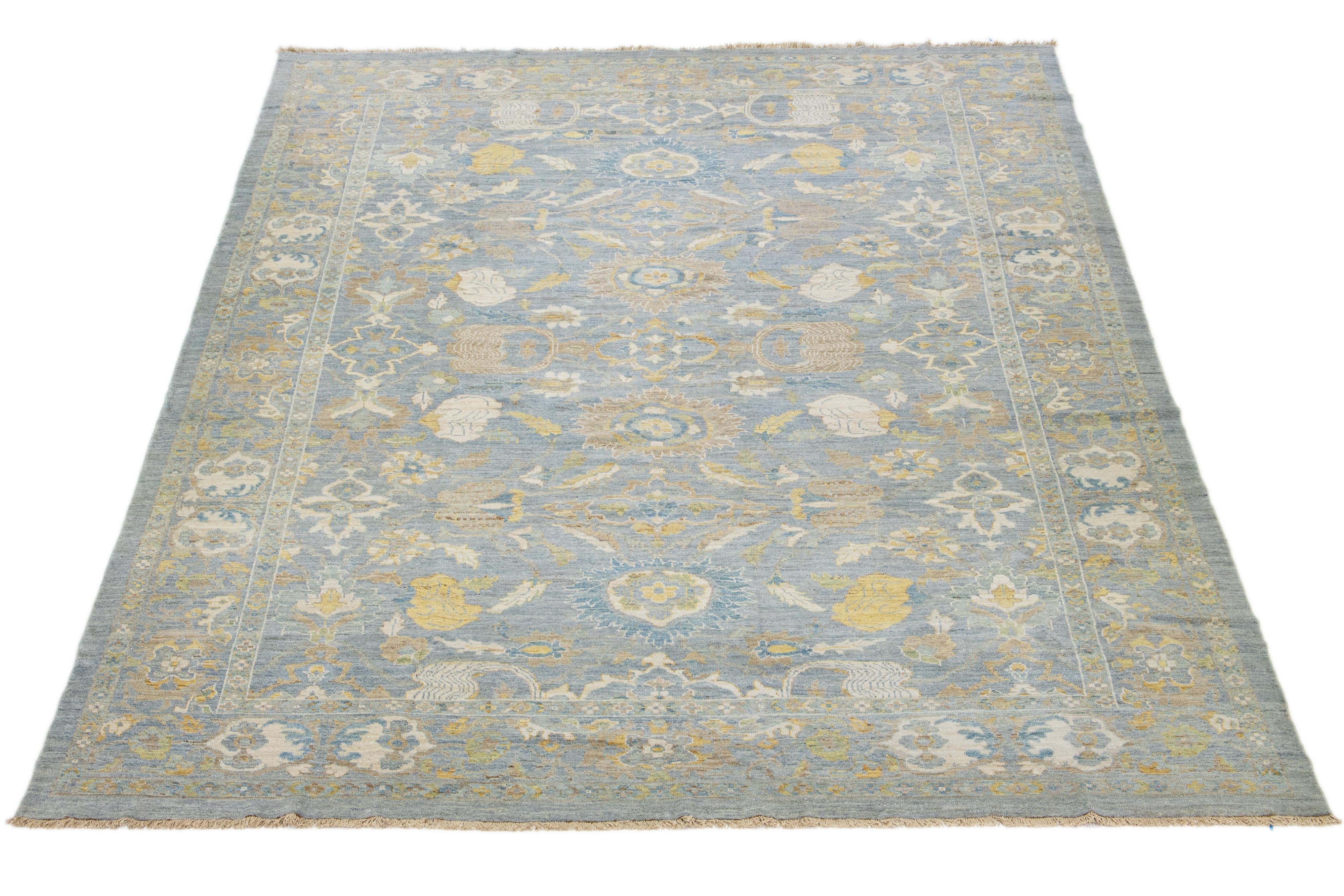 Dieser handgeknüpfte Wollteppich hat einen hellblauen Hintergrund, der mit braunen und gelben Akzenten in einem Allover-Muster verziert ist.

Dieser Teppich misst 10'11'' x 14'4''.