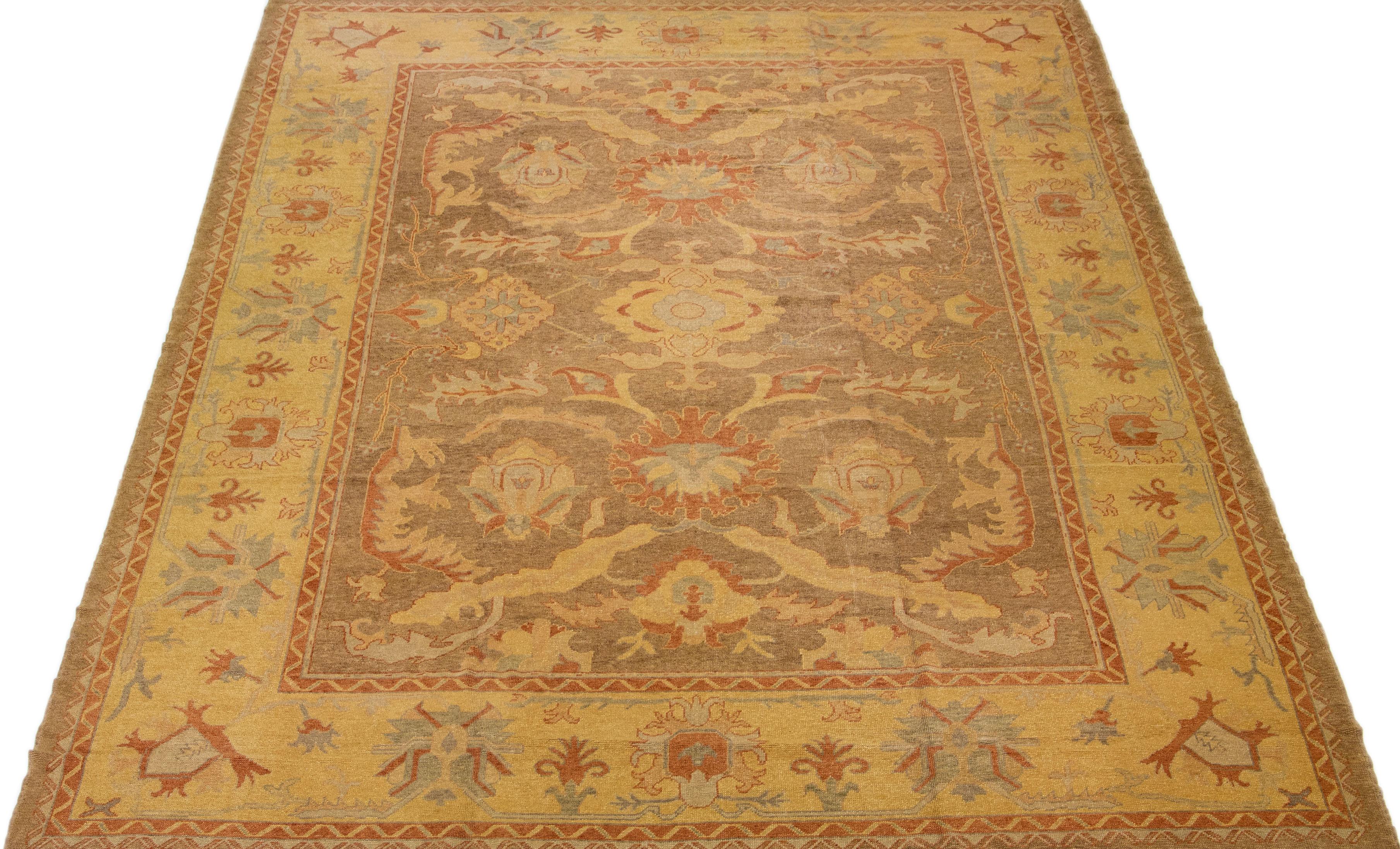 Beautiful modern Turkish Oushak hand-knotted wool rug with a light brown color field. This rug has blue, yellow, and rust accents in a gorgeous large-scale floral motif.

This rug measures: 13'5