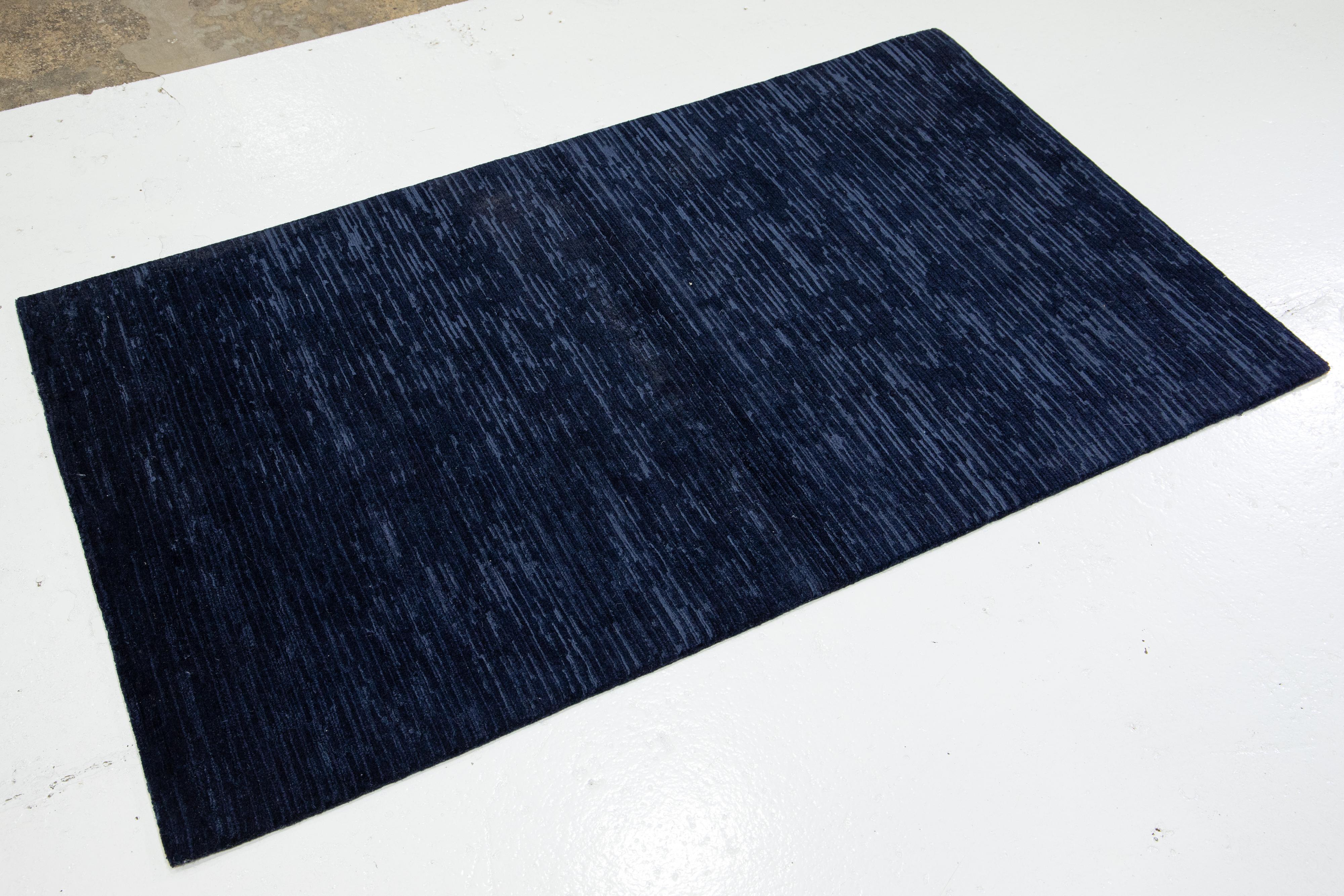 Questo moderno tappeto Custom presenta un'audace miscela di colori e texture. La tinta unita setosa può essere apprezzata da qualsiasi angolazione e la luce danzerà sul motivo scintillante mentre ti muovi sul pavimento. I ricchi pigmenti del blu