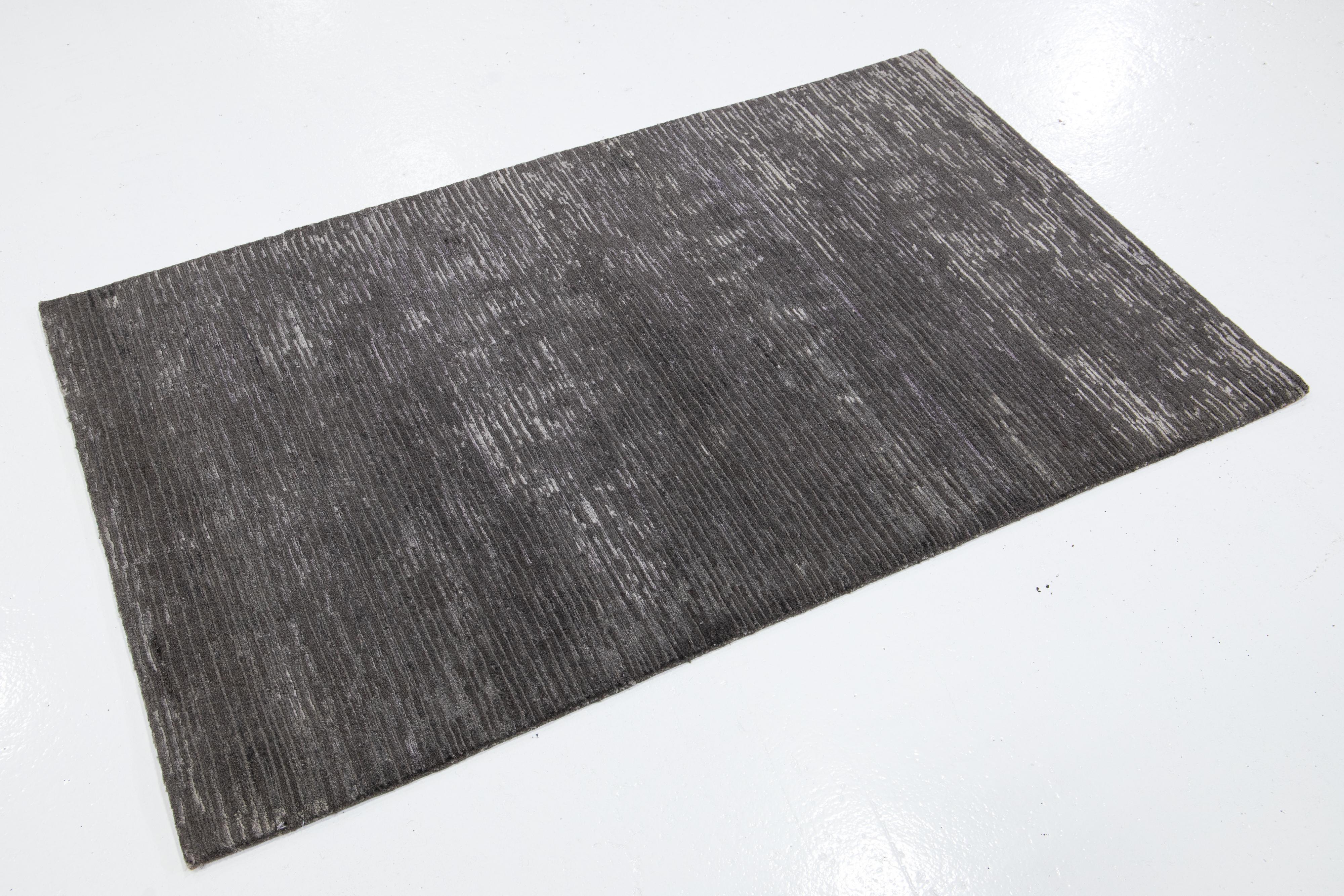 Questo moderno tappeto Custom presenta un'audace miscela di colori e texture. La luce danzerà su questo motivo scintillante mentre ti muovi sul pavimento. Il grigio caldo intervallato da tonalità più scure aggiunge un rivestimento drammatico ai