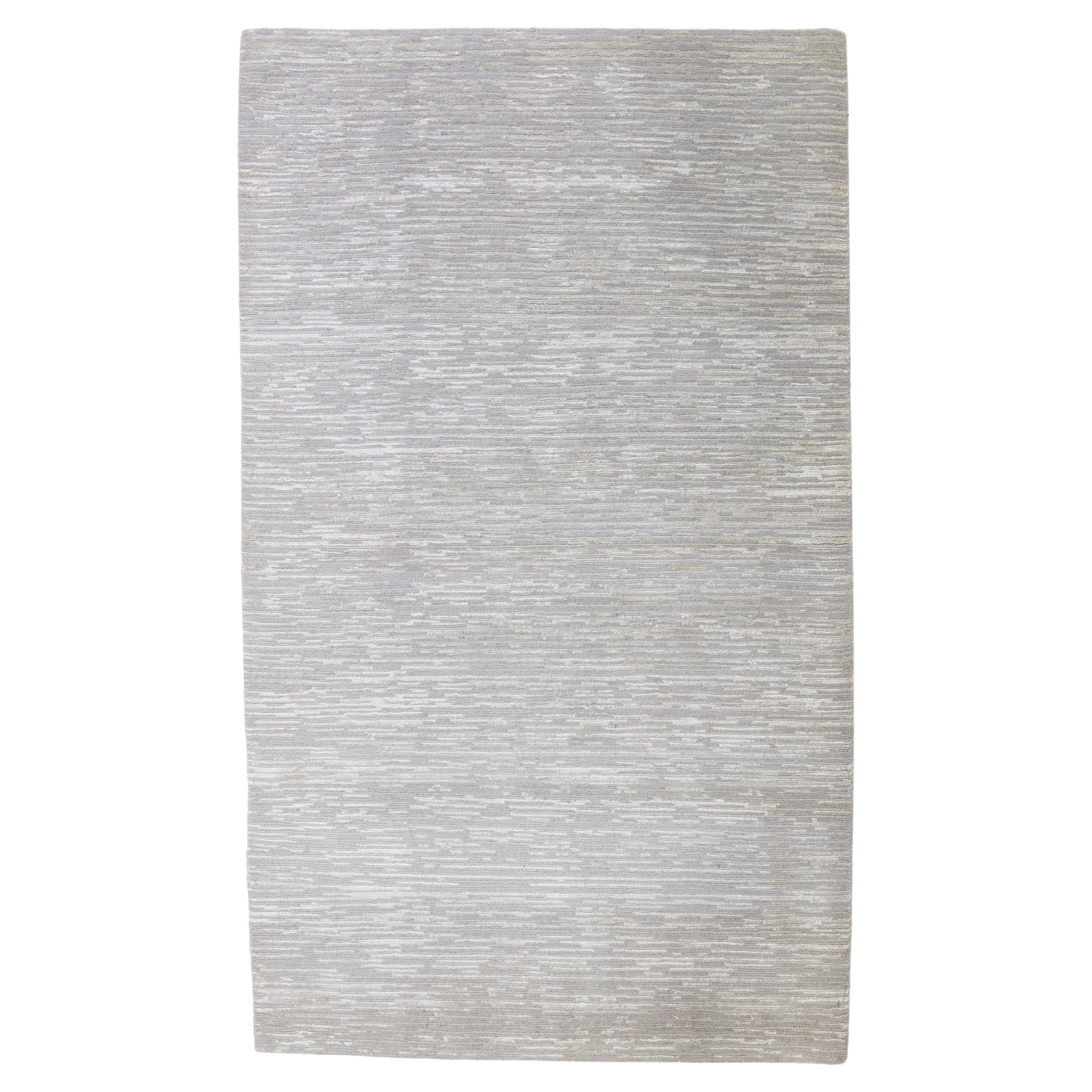 Tappeto in lana e seta di bambù dal design moderno in colore grigio argento proveniente dal Nepal