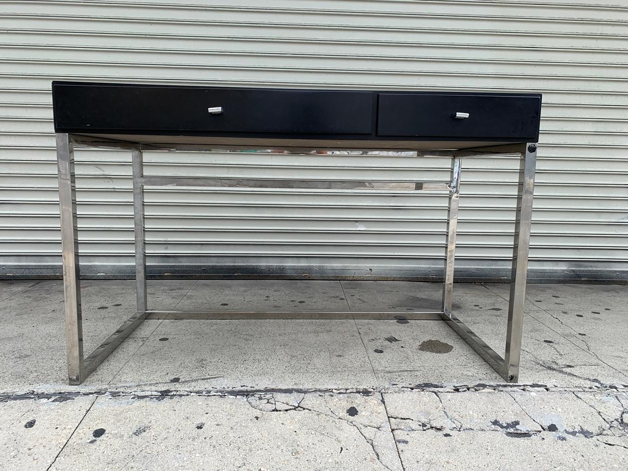 Modern desk made in solid wood and lacquered finish sitting on a chrome base.

The desk has one drawer and a sliding tray for the keyboard.

The piece is heavy and well made however it needs some love to bring it back to its glory