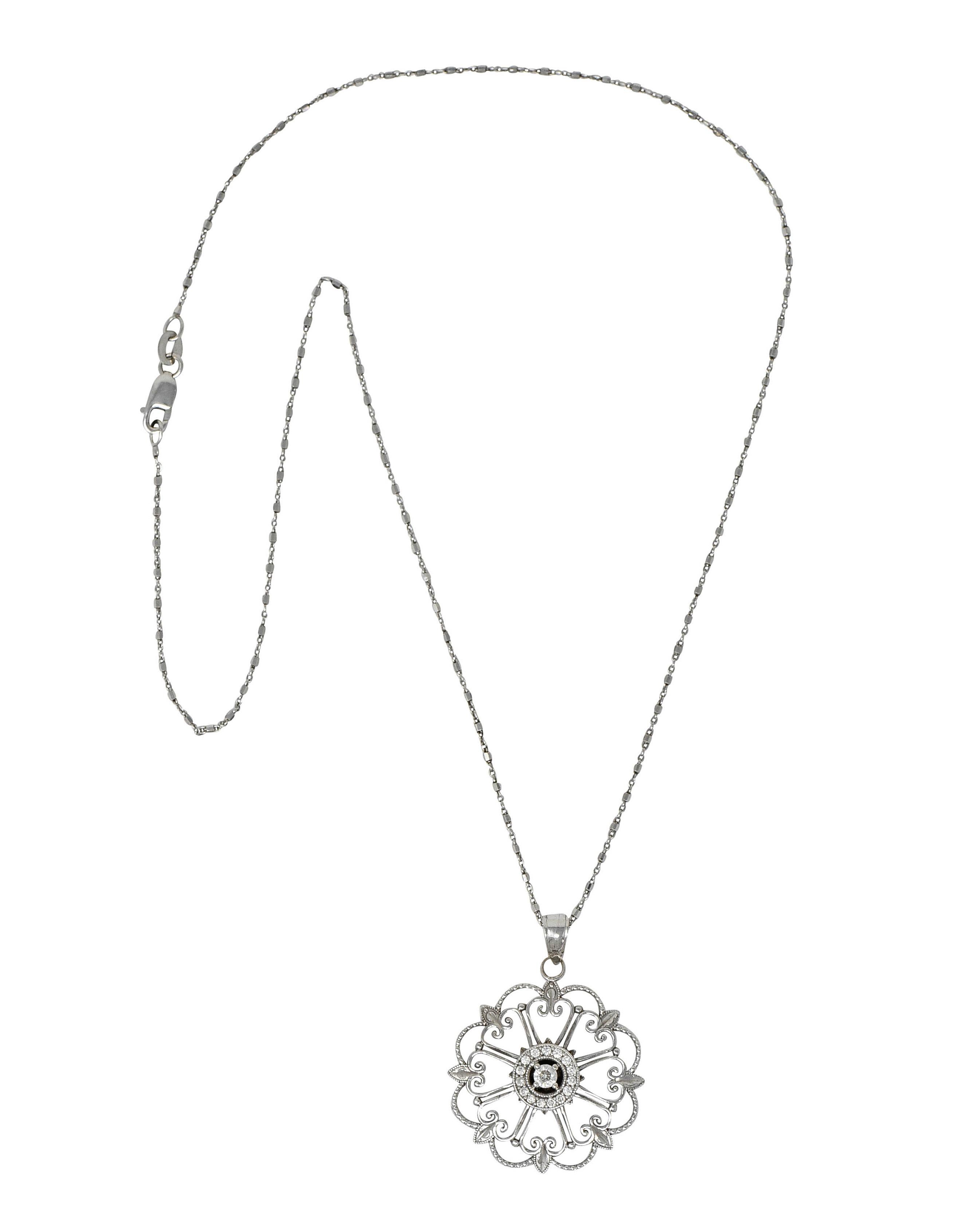 Pendant is designed as a stylized floral mandala with foliate, milgrain, and scrolled volutes

Centering a round brilliant cut diamond surrounded by a circular diamond halo

Weighing in total approximately 0.25 carat - eye clean and