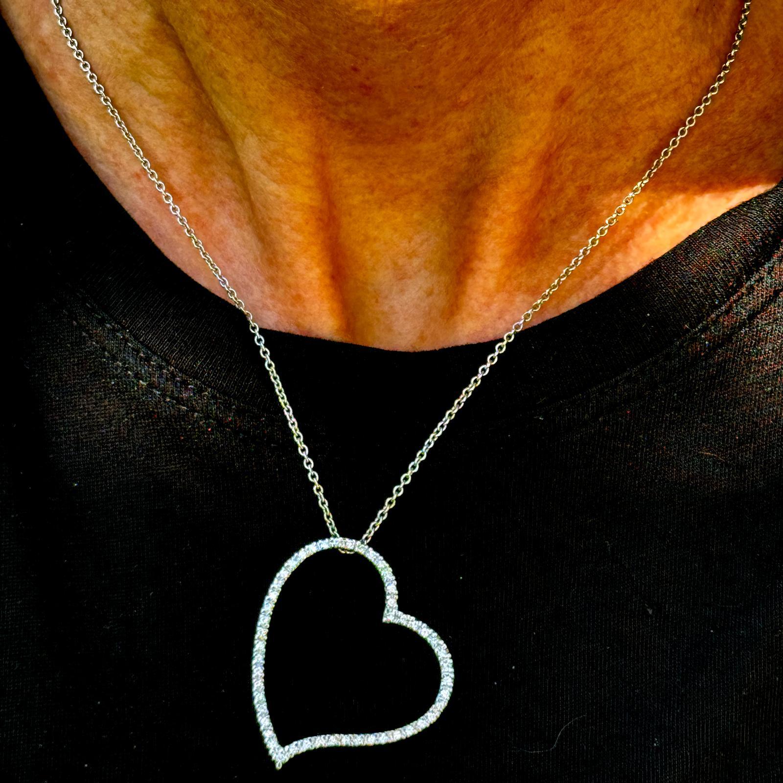 Ce pendentif contemporain en or blanc 14k à cœur ouvert flottant orné de diamants rayonne d'une élégance moderne. Le design en forme de cœur est orné de 50 diamants ronds de taille brillant, totalisant environ 0,50 carats, de couleur G-H et de