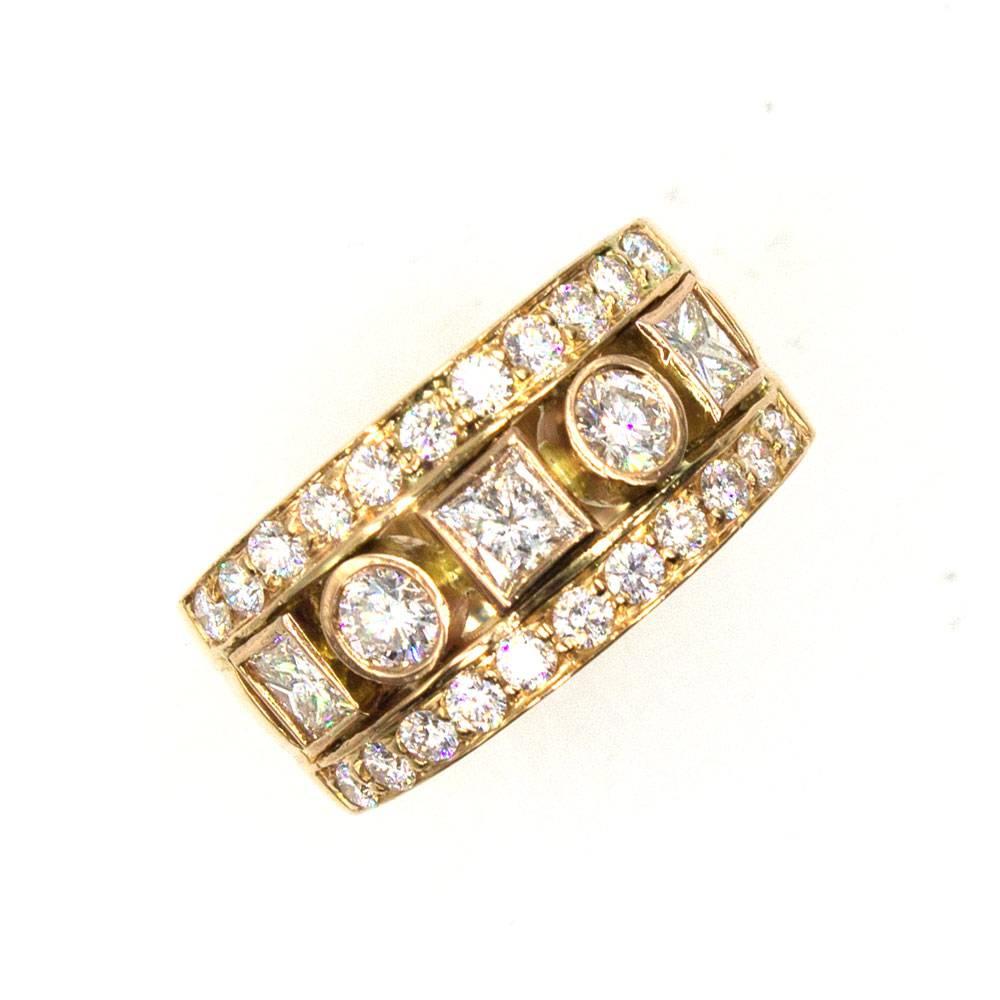 This stylish diamond band is fashioned in 18 karat rose gold. Two rows of round brilliant cut diamonds surround a row of princess cut and alternating round brilliant cut diamonds. There is a total of 1.50 carat total weight. The band measures 10mm