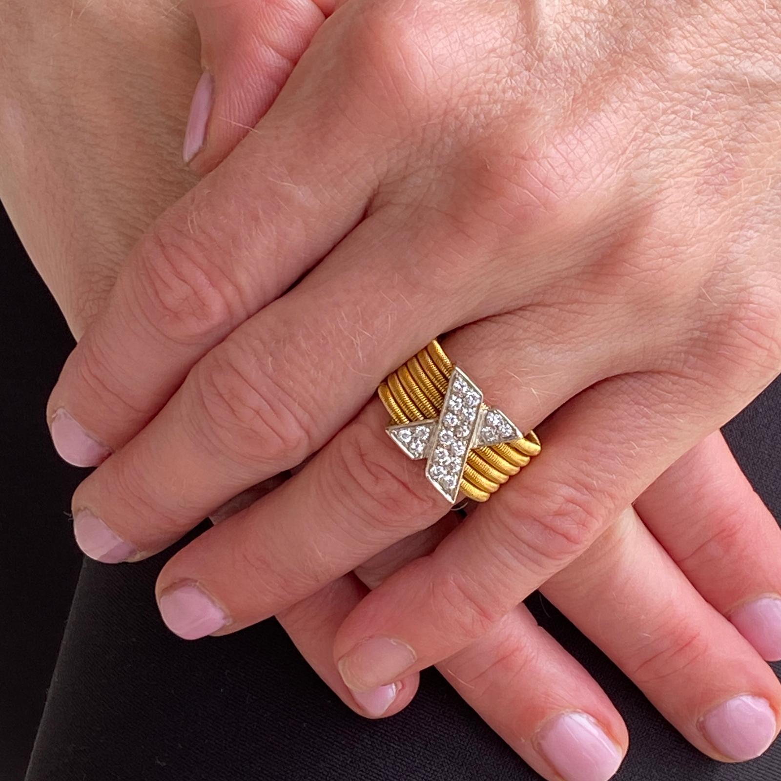 This stylish diamond X ring is crafted in 18 karat yellow and white gold. The white gold X features 18 round brilliant cut diamonds weighing approximately .50 carat total weight and graded G-H color and VS clarity. The 6 row woven yellow gold band