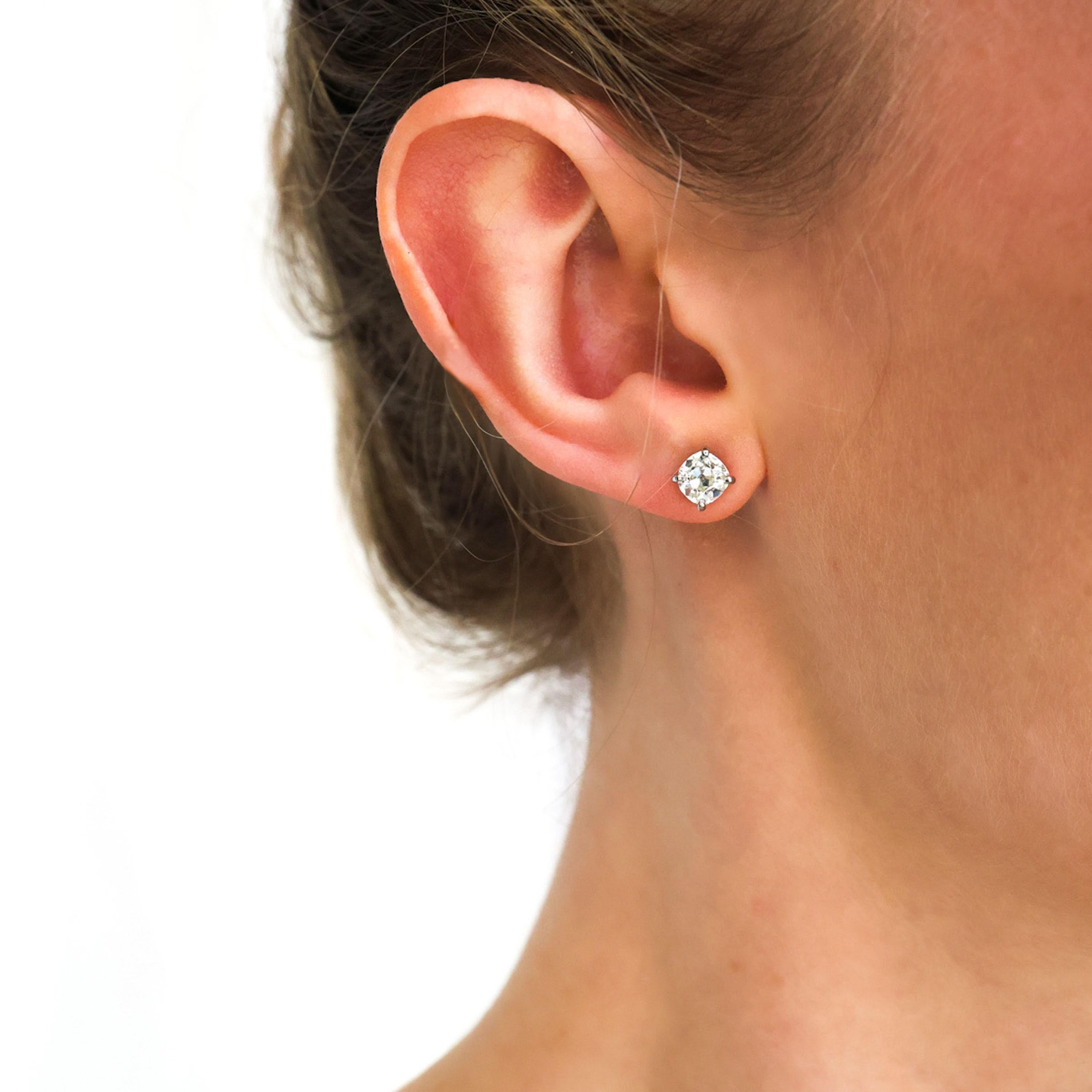 A pair of modern diamond stud earrings, each set with an old-cut diamond, mounted in platinum, four claw basket settings, with posts and alpha clip fittings, with a total diamond weight of 1.92 carats. In our opinion the colour is I to J and our