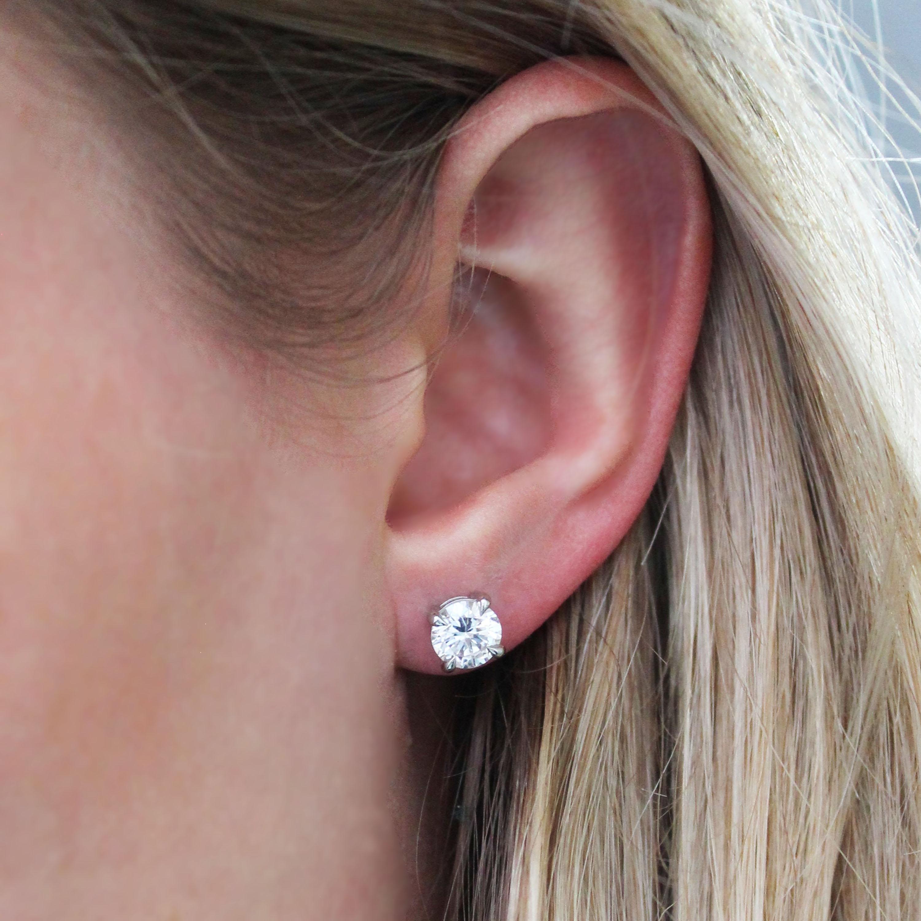 A pair of modern diamond stud earrings, with round brilliant-cut diamonds with a total diamond weight of approximately 2.11 carats, one diamond weighs approximately 1.12 carats, in our opinion it is H colour and our opinion of the clarity is SI1,