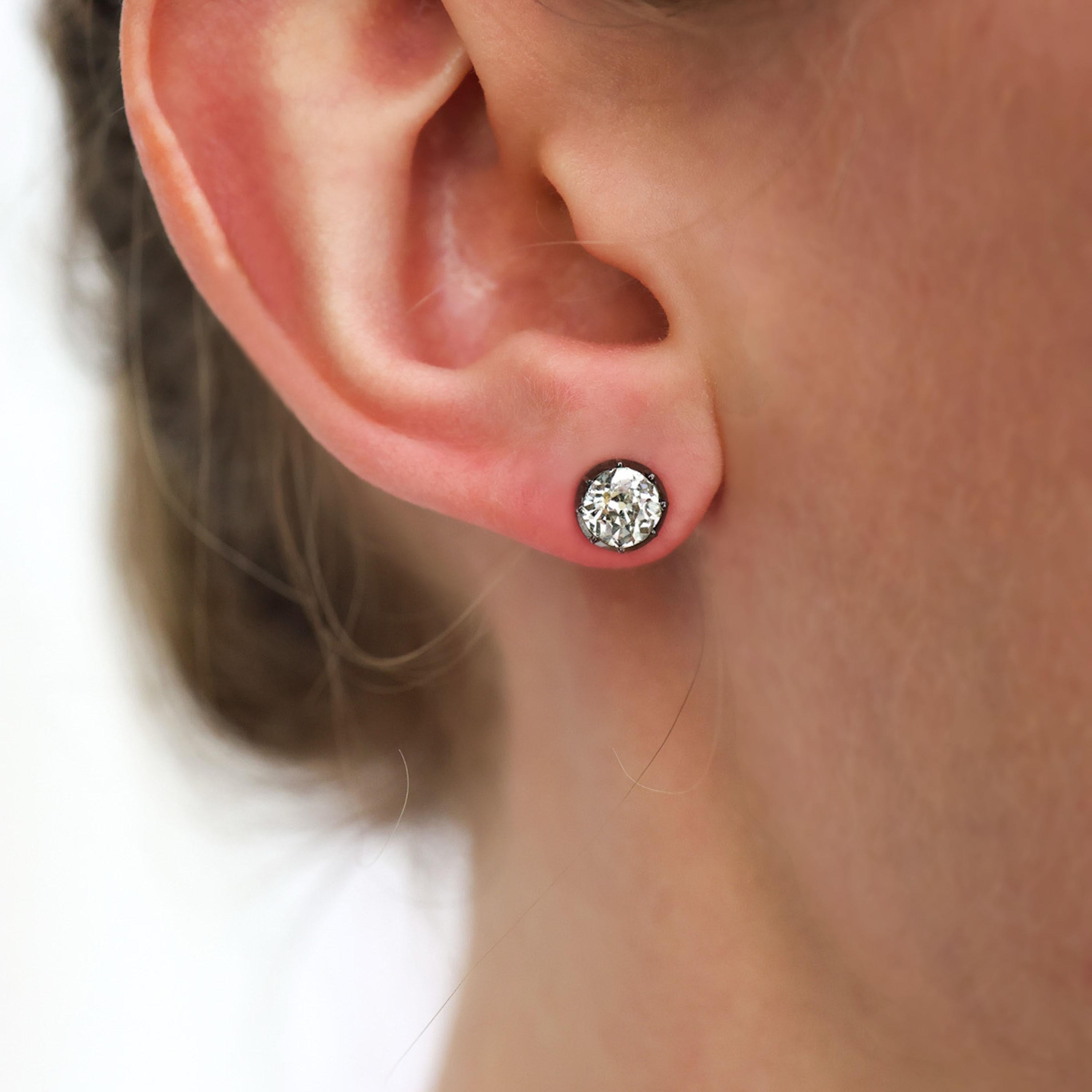 A pair of modern diamond stud earrings, each set with old-cut diamonds, in silver-upon-gold cut down settings, on gold posts, with alpha clip fittings, with a total diamond weight of 1.75 carats. In our opinion the colour is I to J and our opinion